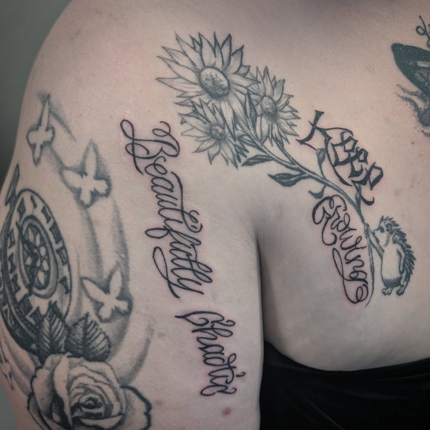 Sunflowers and script black and grey tattoo on the shoulder by Markus Hicks