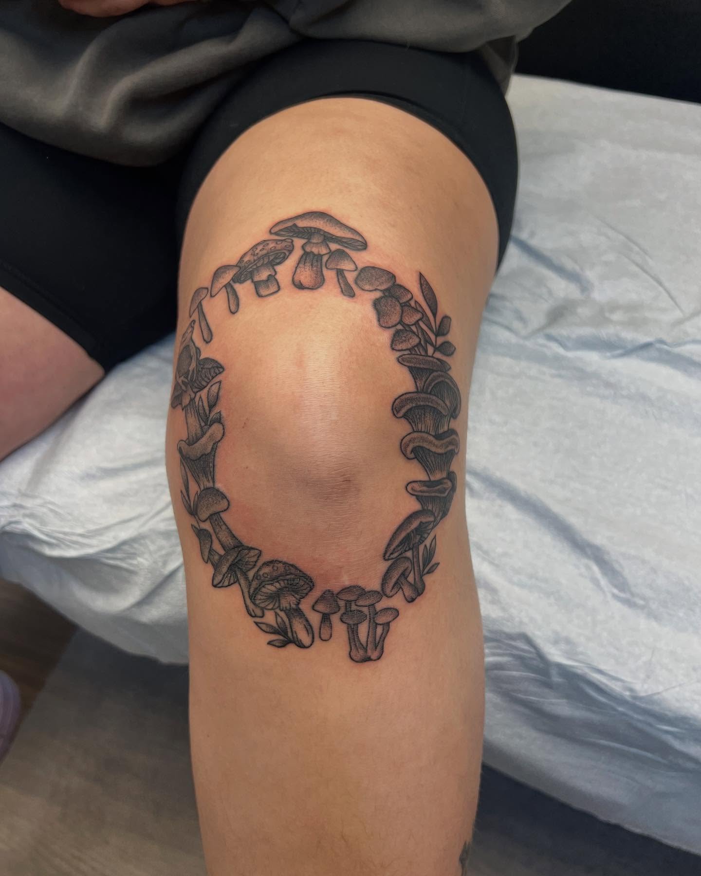 Mushroom wreath black and grey tattoo on the thigh by Cody Marl