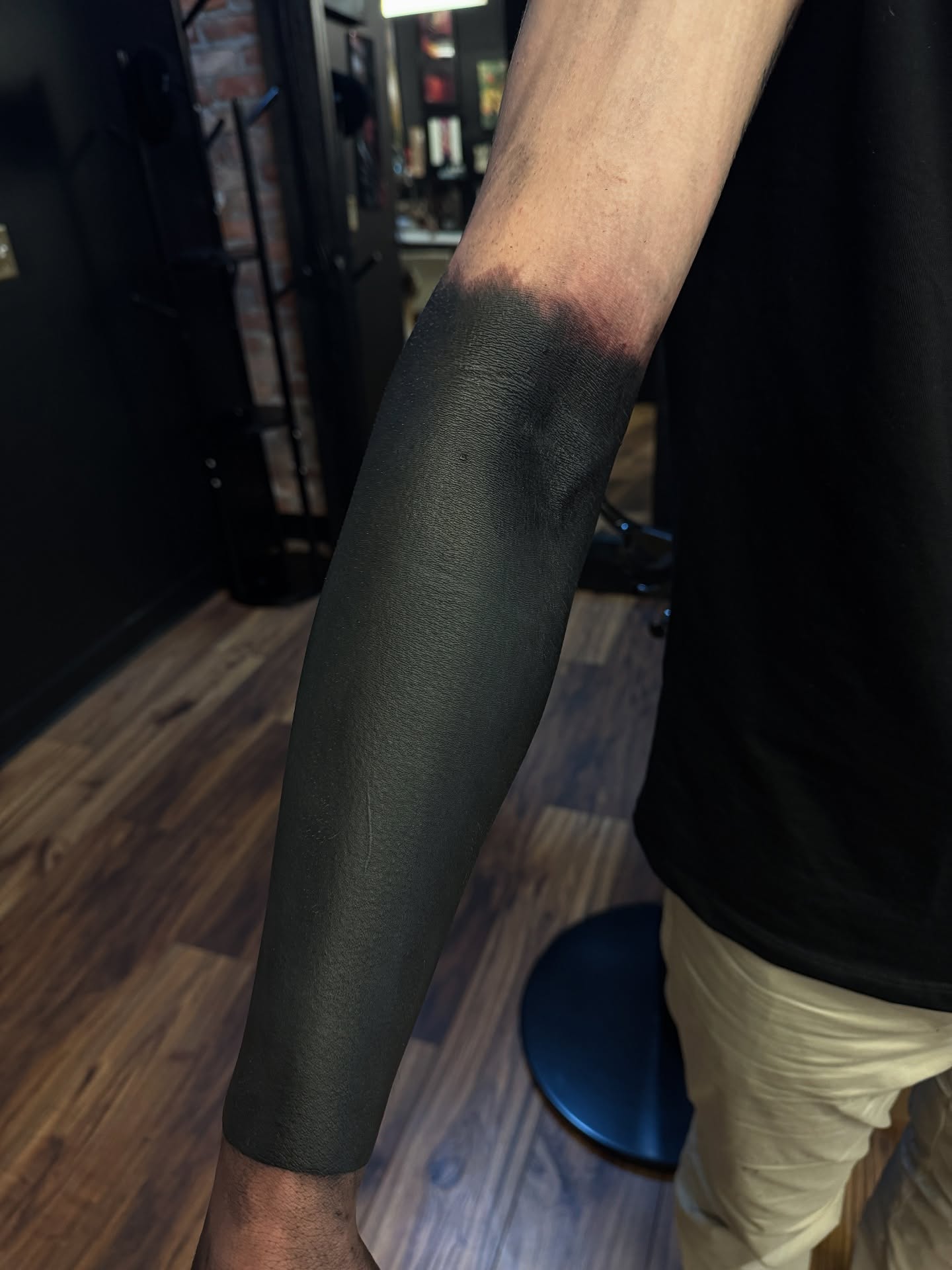 Solid black sleeve black and grey tattoo on the forearm by Denver Blackout Tattoo Specialist - Anthony