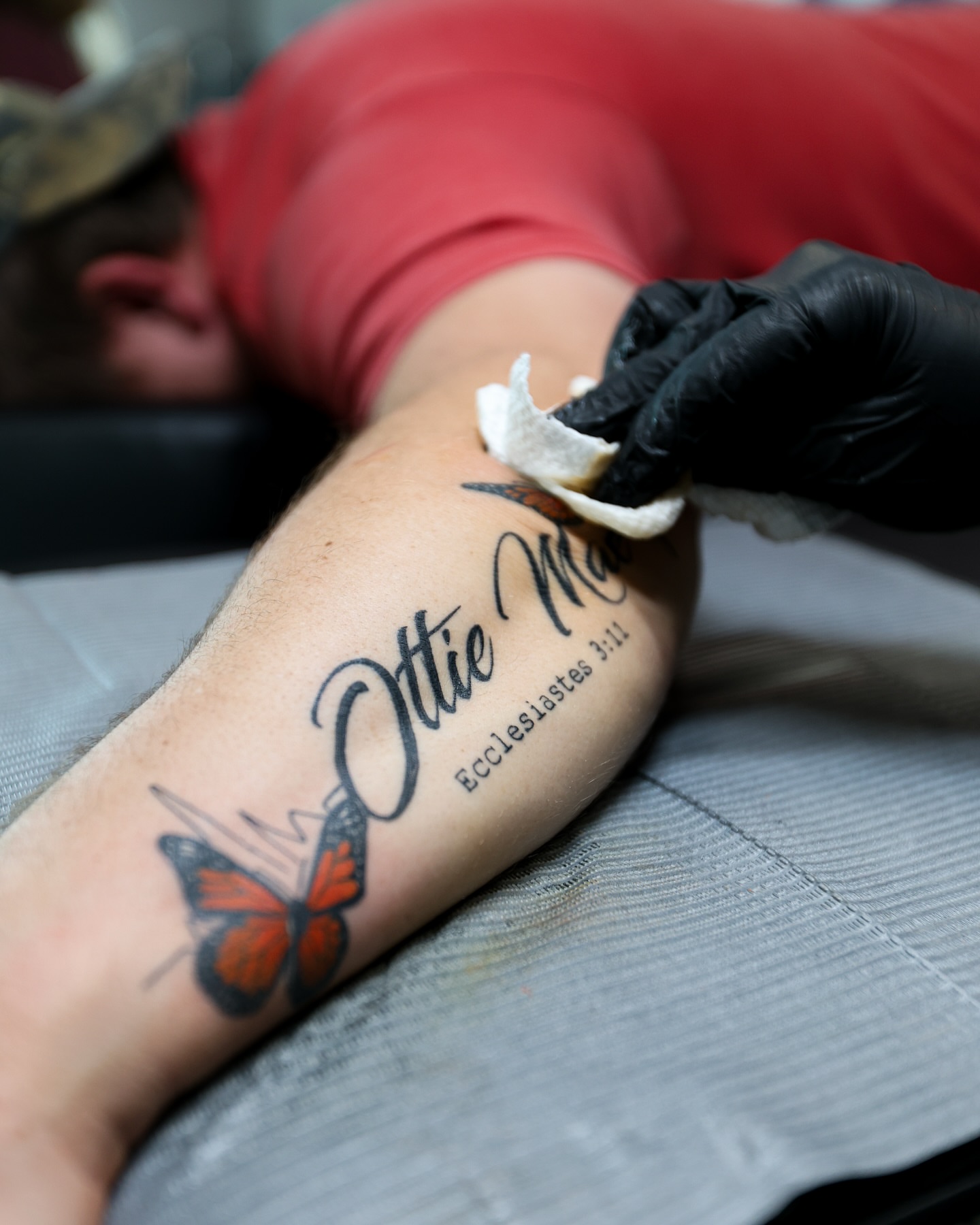Butterfly and name black and grey tattoo on the forearm by Charlotte Tattoo Artist