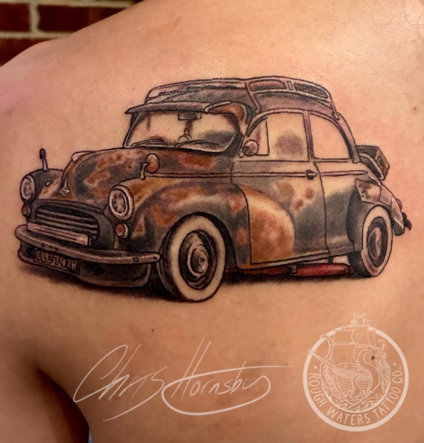 Rusty car realism tattoo on the back by Chris Hornsby