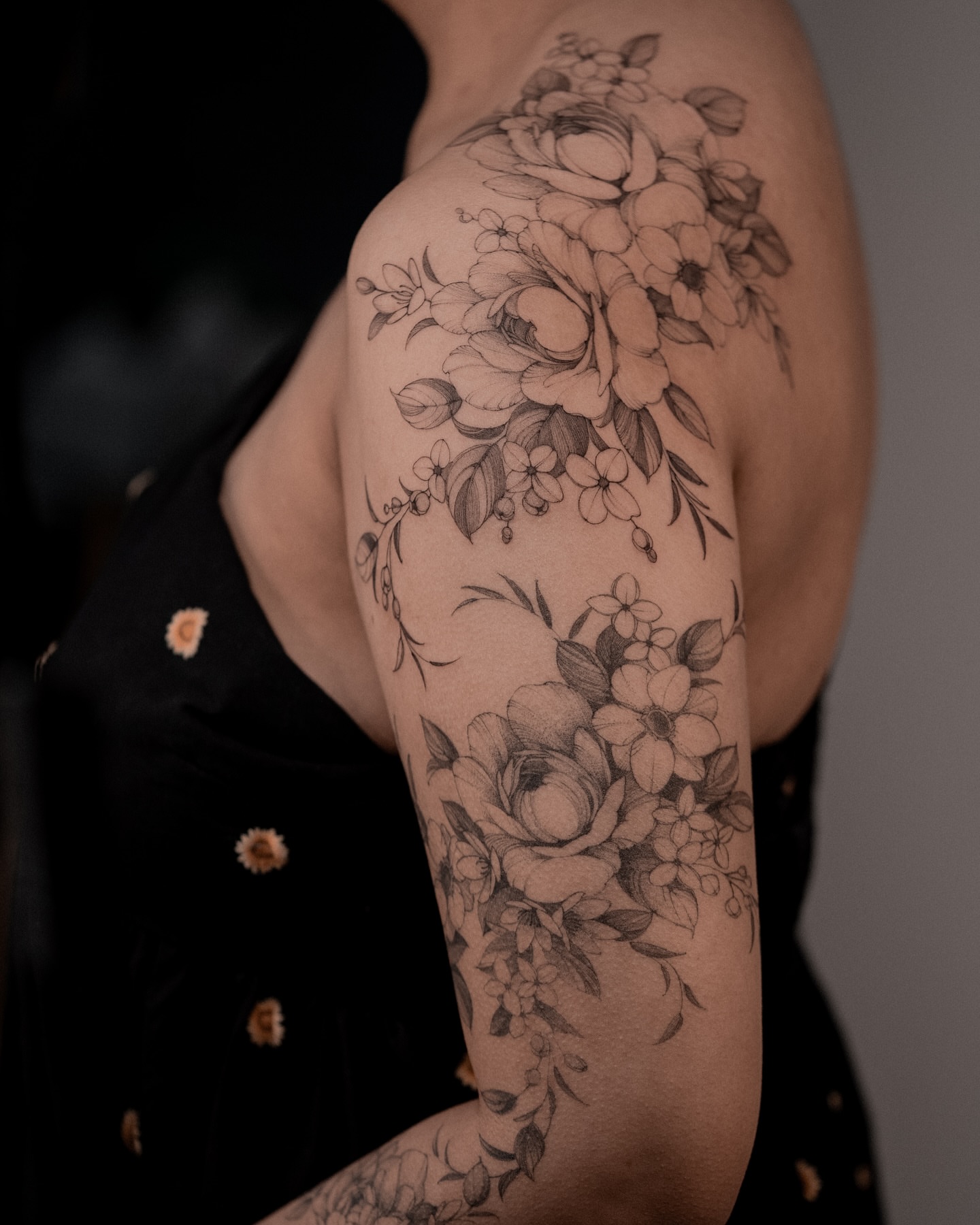 Floral bouquet black and grey tattoo on the upper arm by Mary Shekh