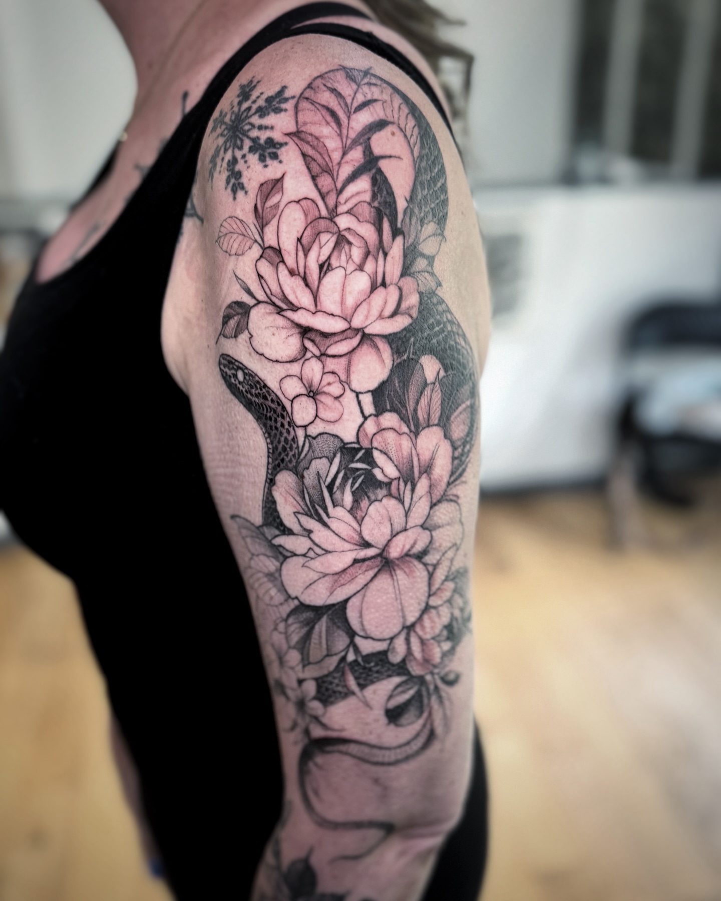 Snake and peony black and grey tattoo on the upper arm by David Gray