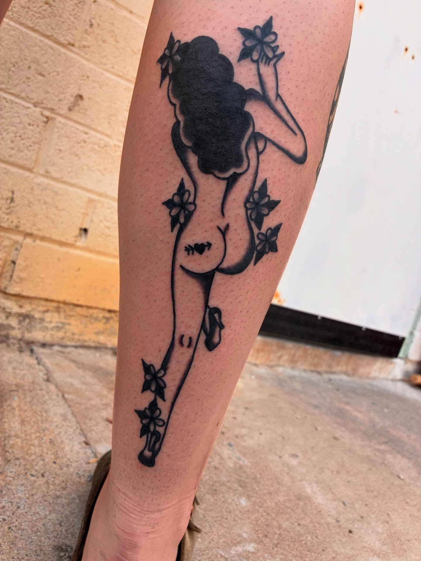 Woman with flowers black and grey tattoo on the leg by Chrissie