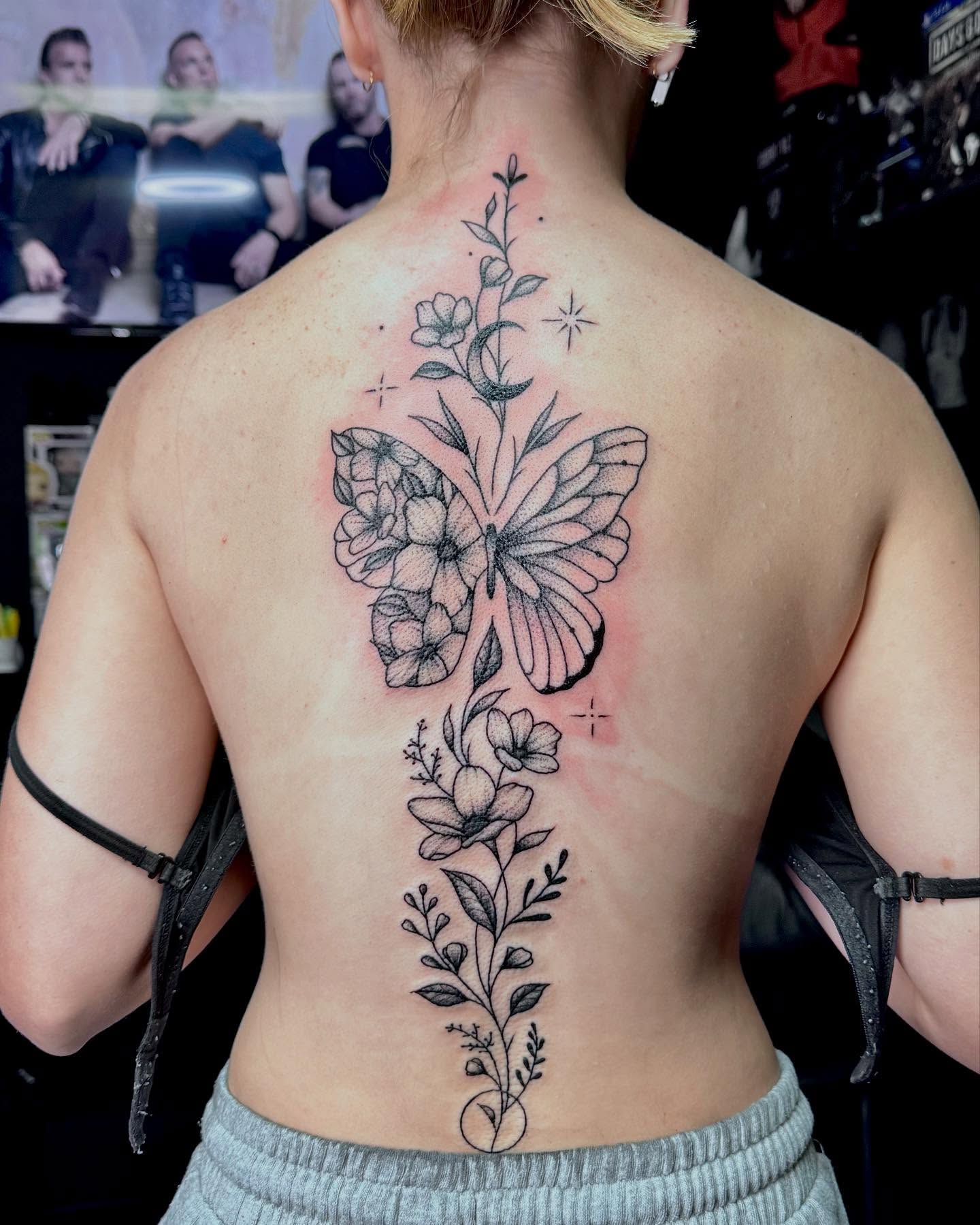 Butterfly and floral black and grey tattoo on the back by Colby McClain