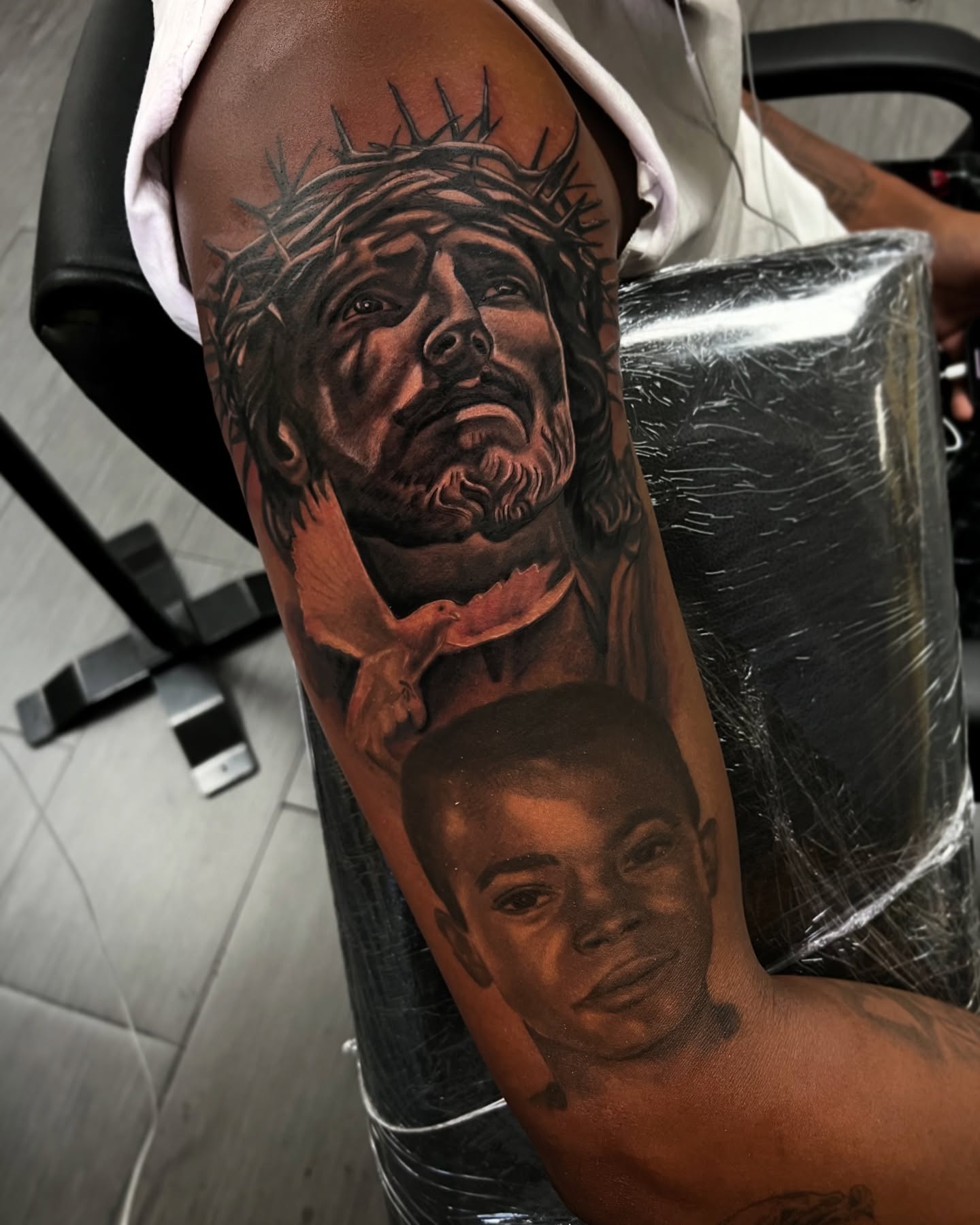 Religious figure and child realism tattoo on the forearm by Vondrae