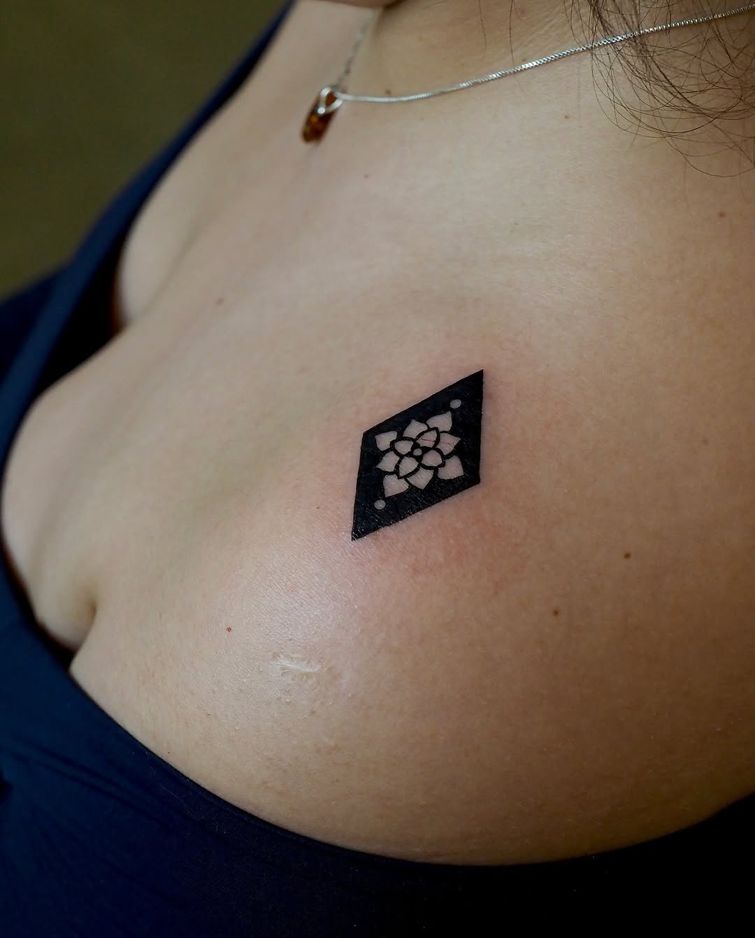 Geometric flower in diamond geometric tattoo on the chest by A. Eye Tat