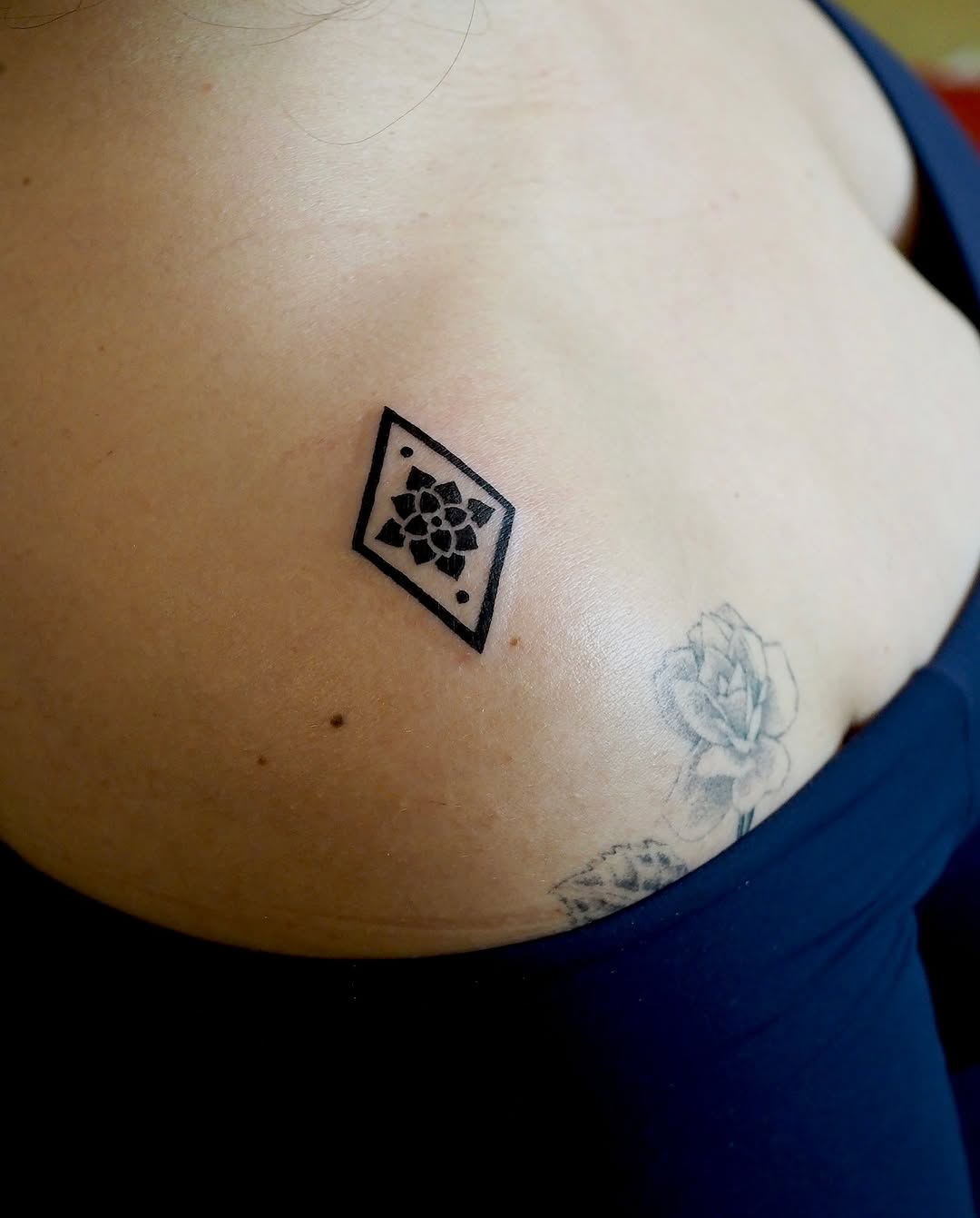 Geometric flower in diamond minimalist tattoo on the chest by A. Eye Tat