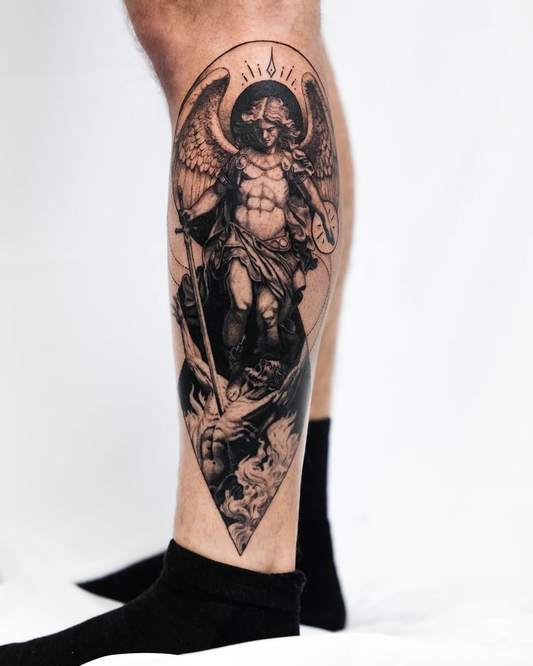 Archangel Michael slaying a demon realism tattoo on the calf by Ben Cisek