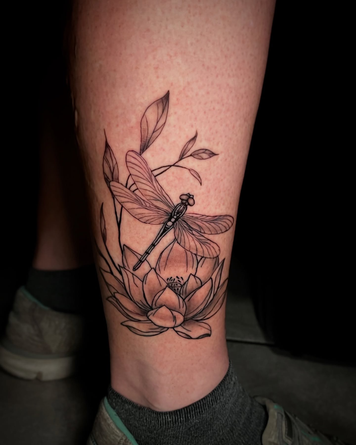 Lotus and dragonfly black and grey tattoo on the calf by Jake, Salt Lake City, Utah