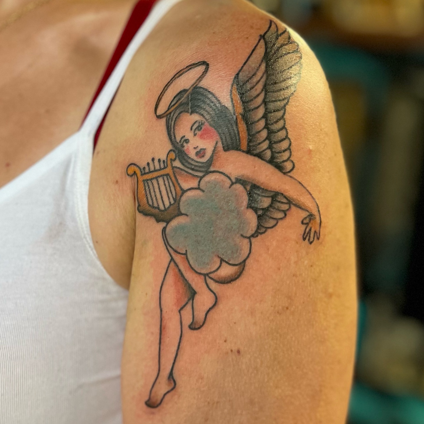 Angel with harp American traditional tattoo on the shoulder by Ashley Camp