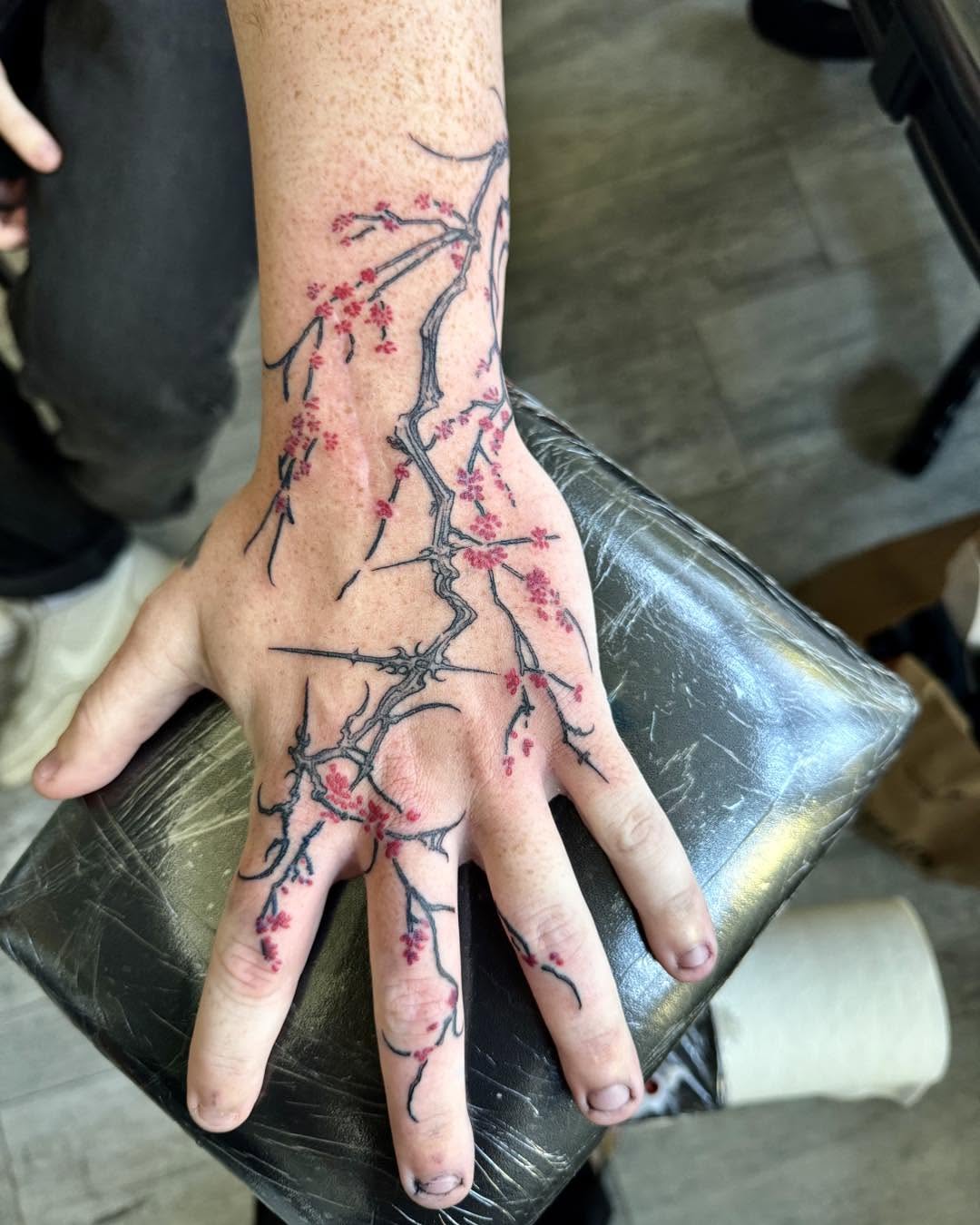 Cherry blossom branches dotwork tattoo on the hand by Quin Walker