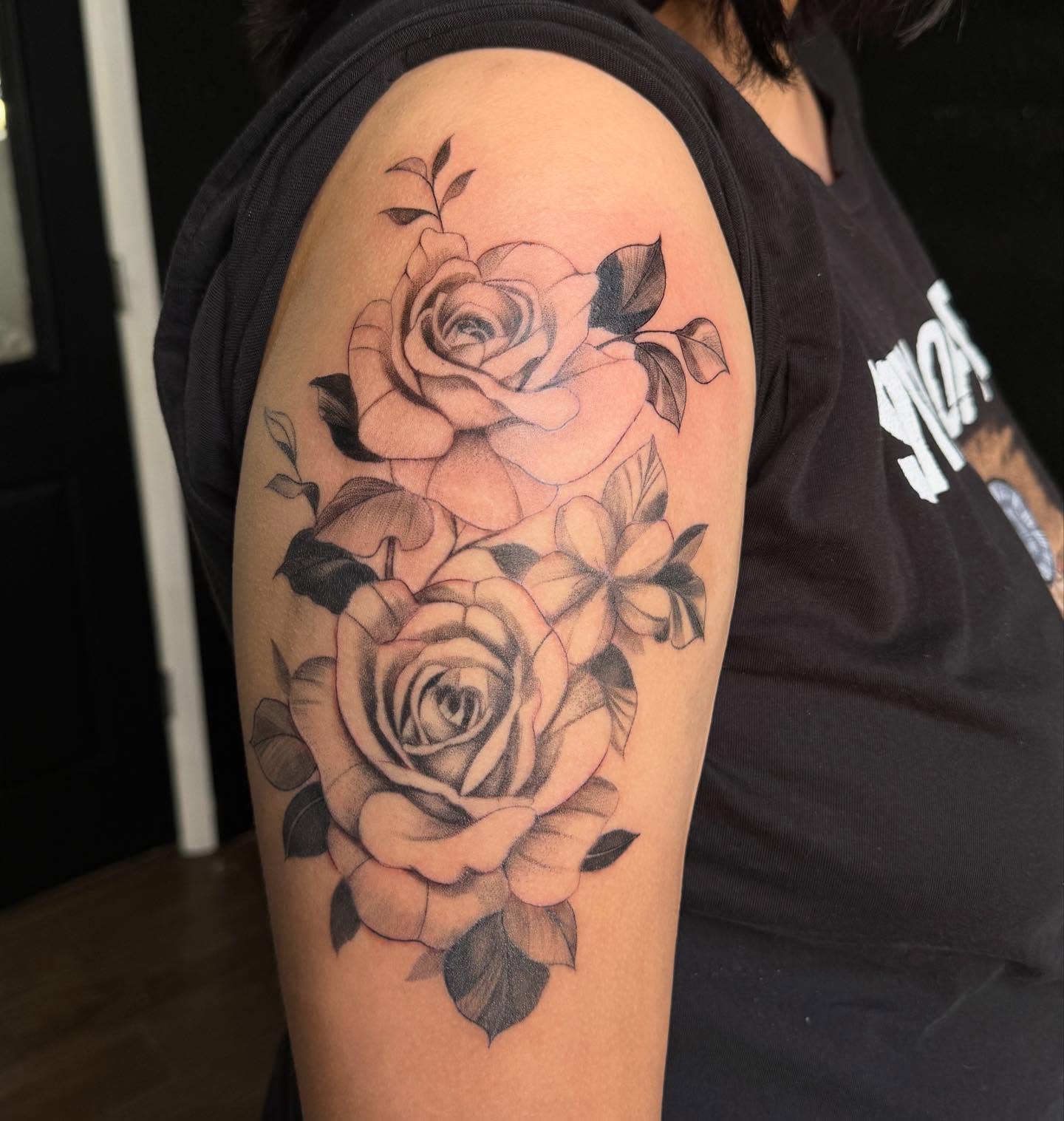 Roses realism tattoo on the upper arm by Mickey