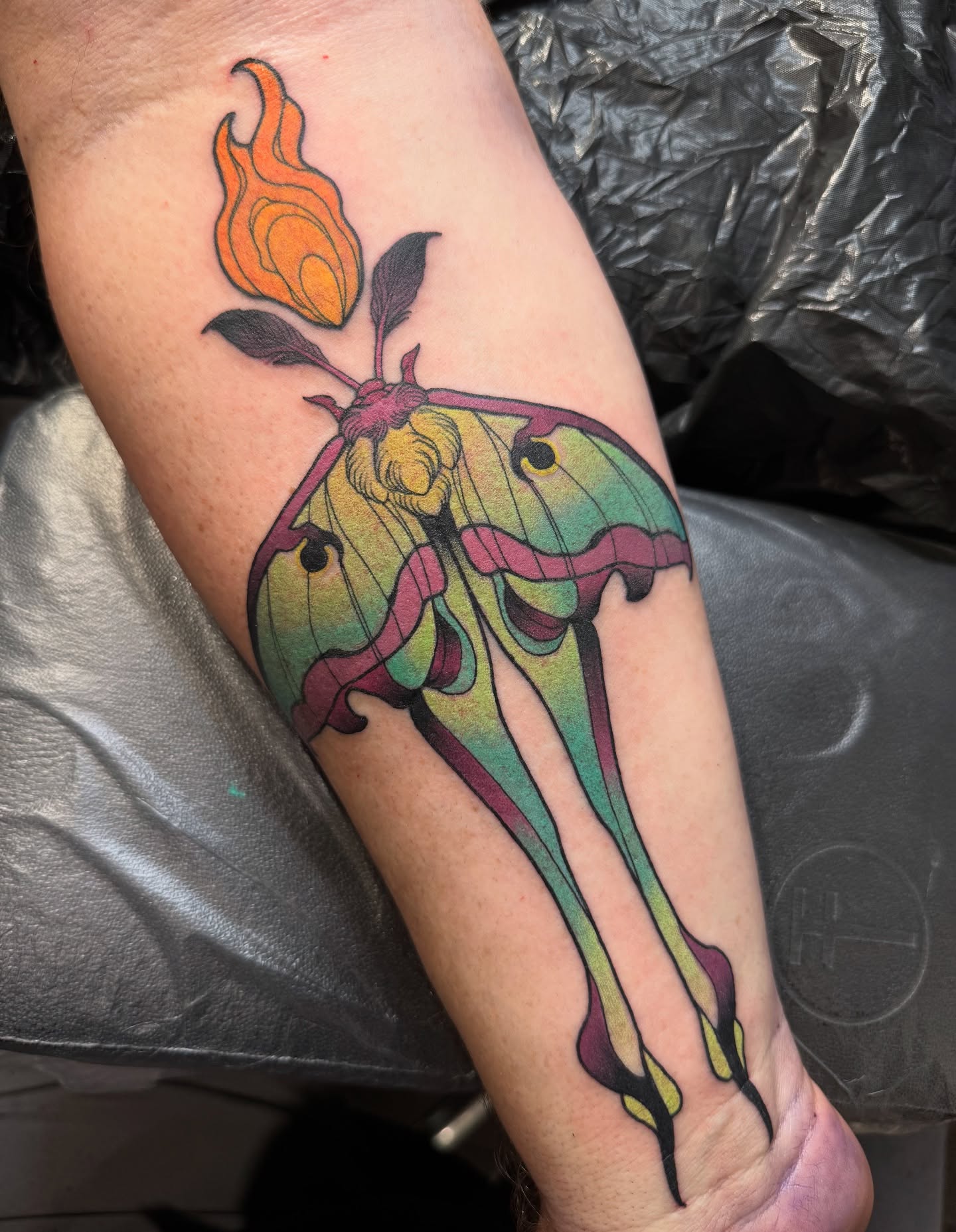 Moth and flame new school tattoo on the forearm by Emmanuel Mendoza