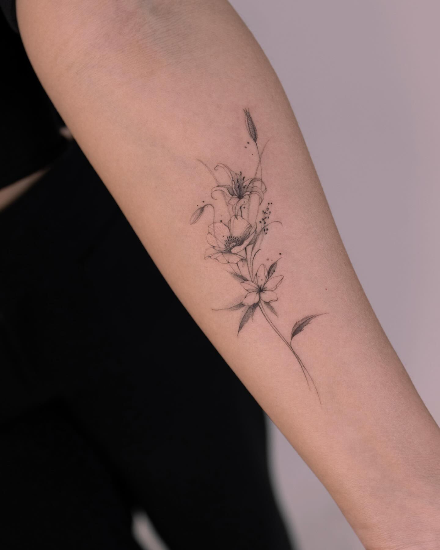 Flowers black and grey tattoo on the forearm by Tattooist hea