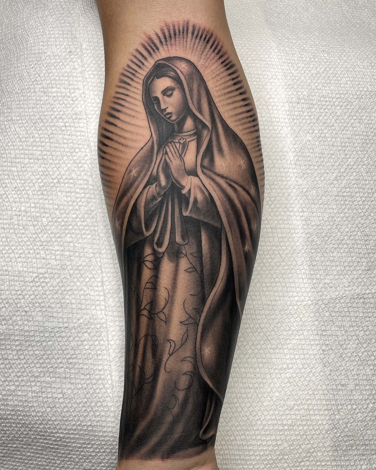 Religious figure black and grey tattoo on the forearm by Alex Ortiz