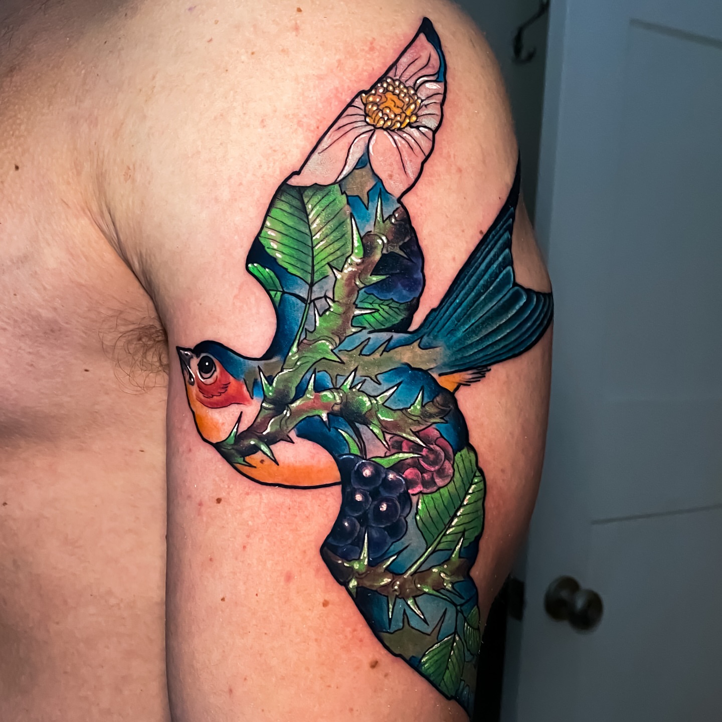 Bird and flower new school tattoo on the upper arm by Eric James, Phoenix, Arizona