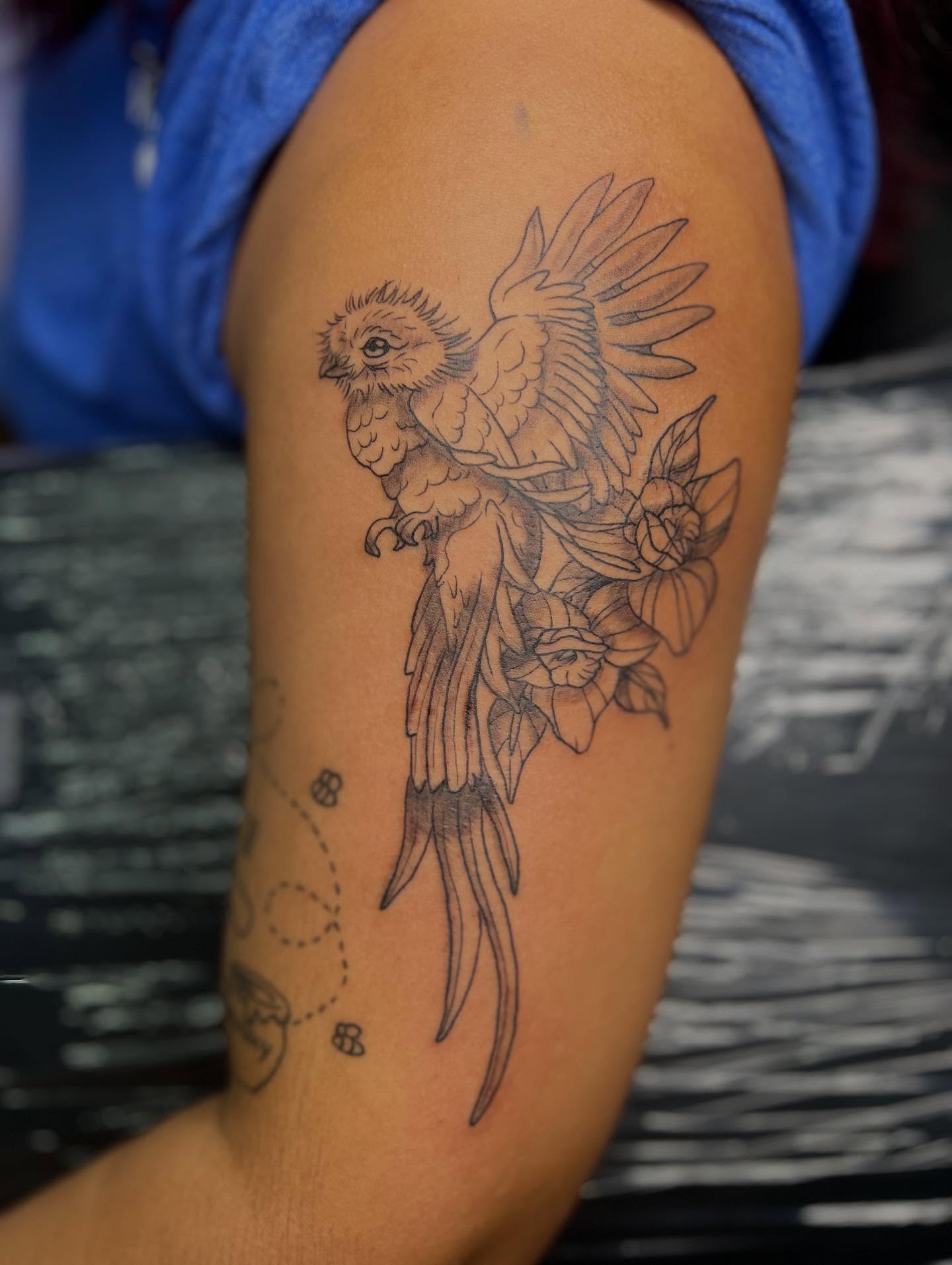 Parrot and flowers black and grey tattoo on the forearm by Monii Arreola