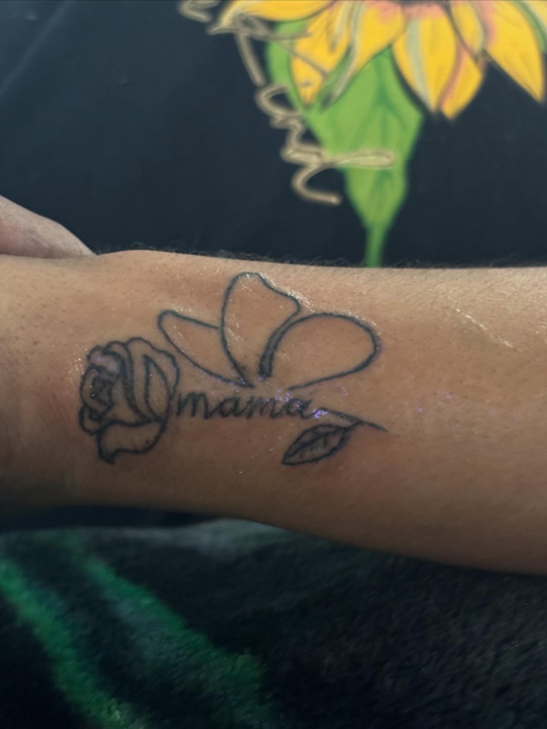 Rose and plumeria with text 'mama' tattoo on the forearm by Ink_ Hustle36