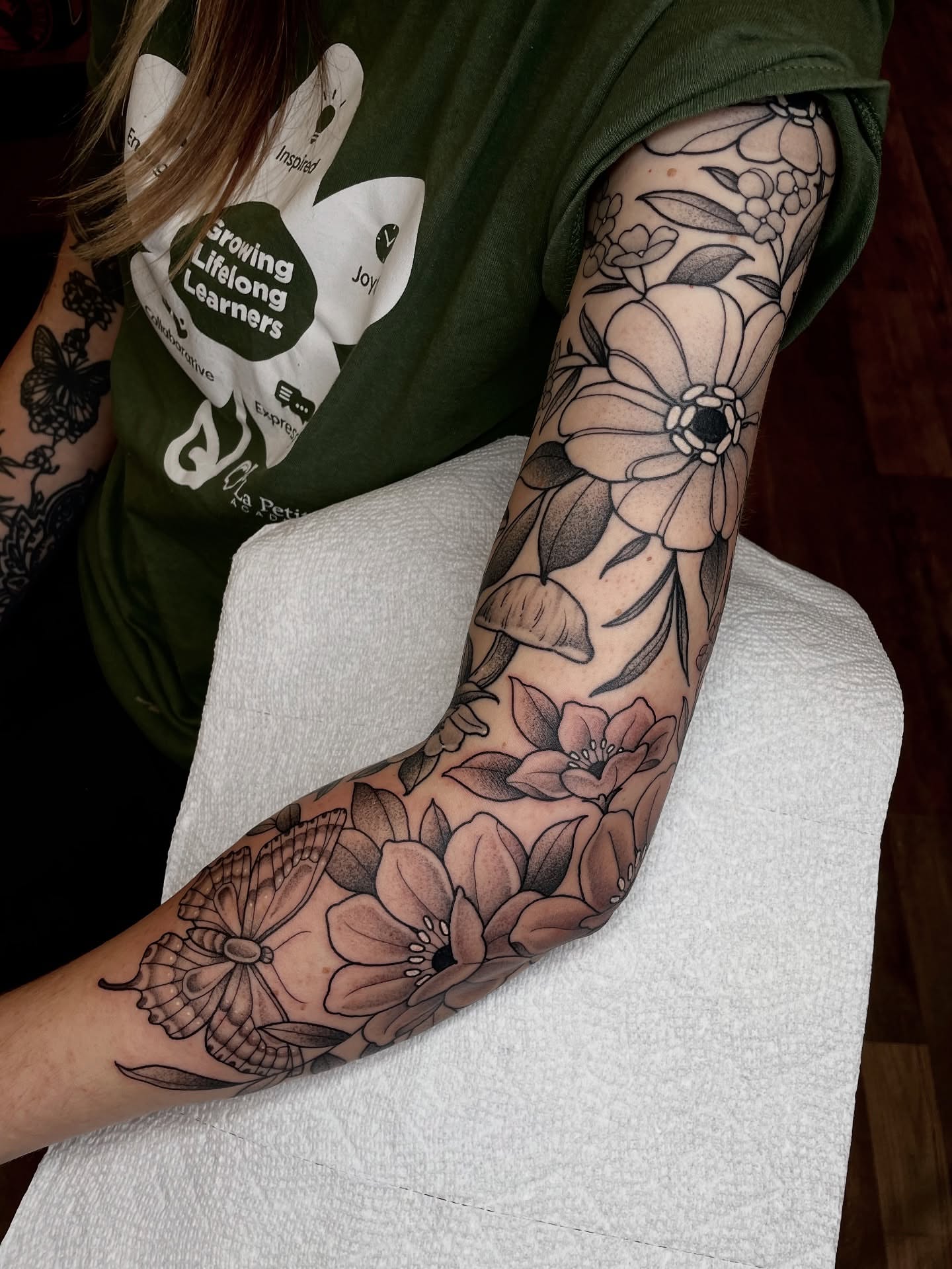 Floral bouquet black and grey tattoo on the forearm by Emily Lux