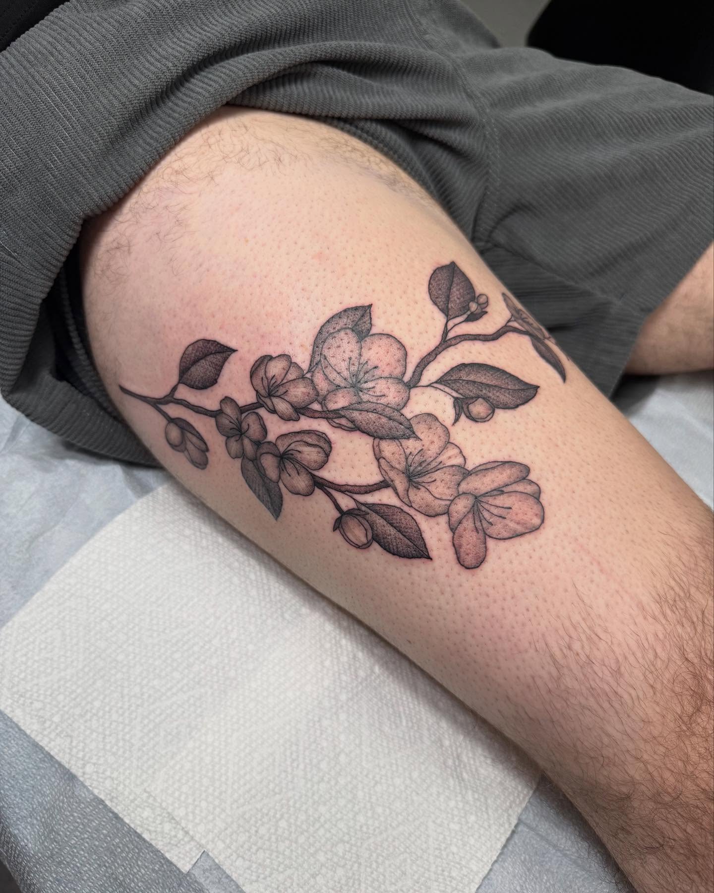 Flower branch black and grey tattoo on the forearm by Maddie Jo DeYoung