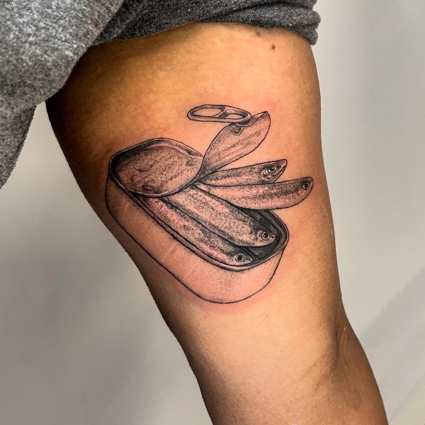 Fish in a tin can dotwork tattoo on the thigh by Nikki Power