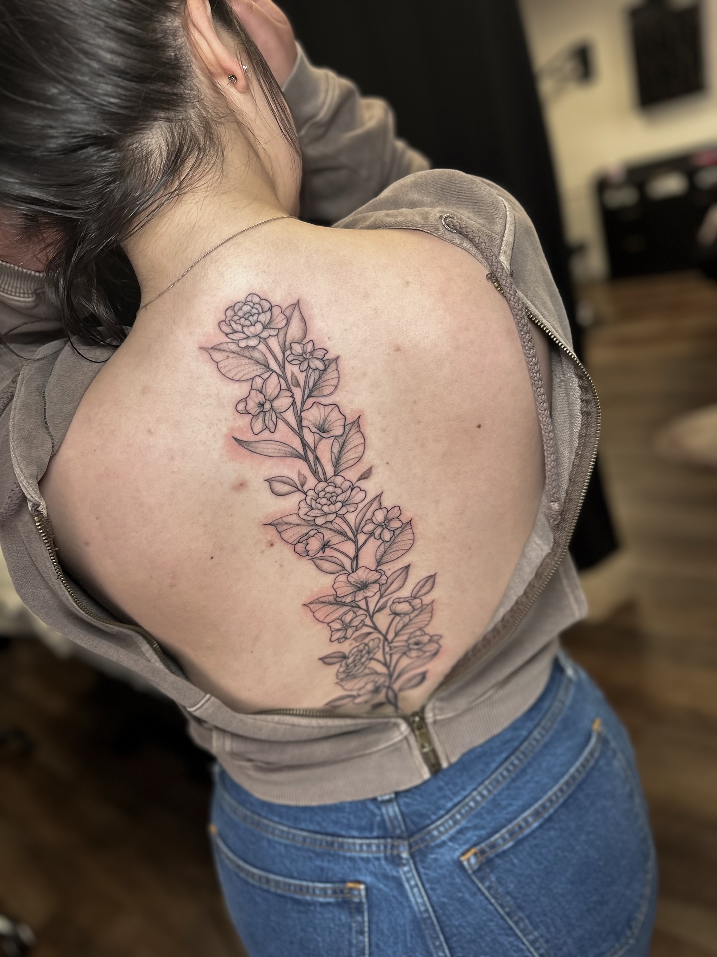 Floral arrangement black and grey tattoo on the back by Priscilla Michels