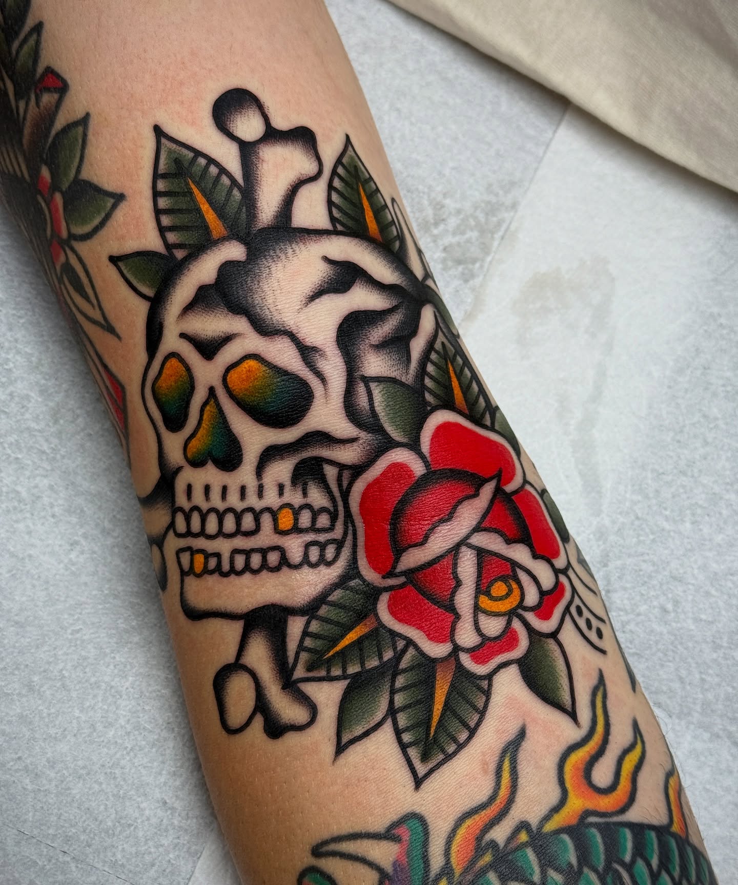 Skull and roses American traditional tattoo on the forearm by Jordan Allen
