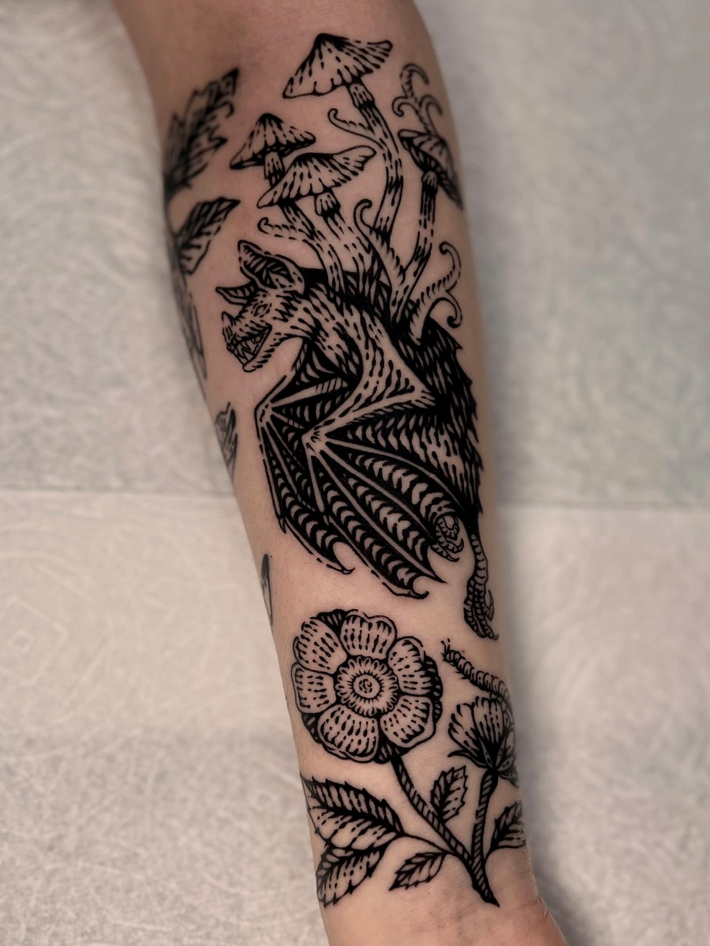 Mushroom and dragon black and grey tattoo on the forearm by Wonny
