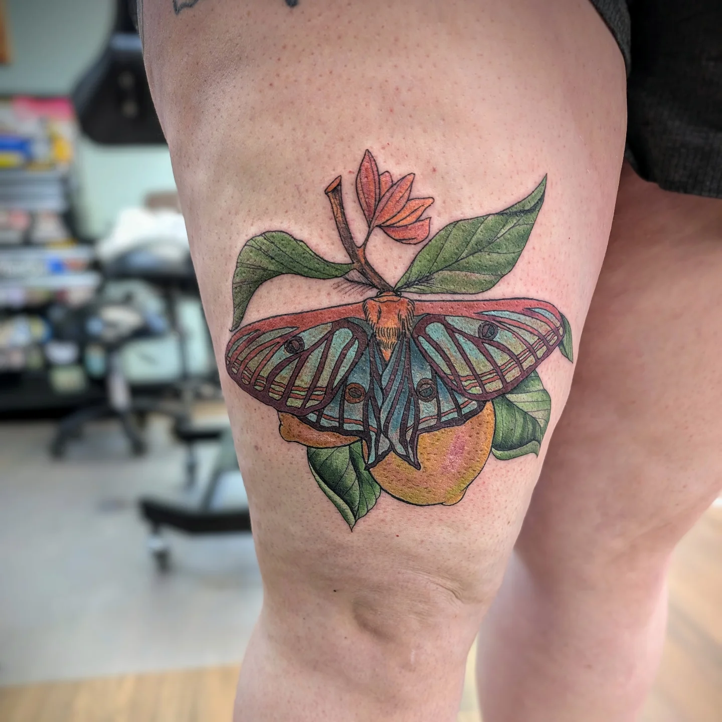 Butterfly and fruit realism tattoo on the thigh by Devon Ward, Portland, Oregon