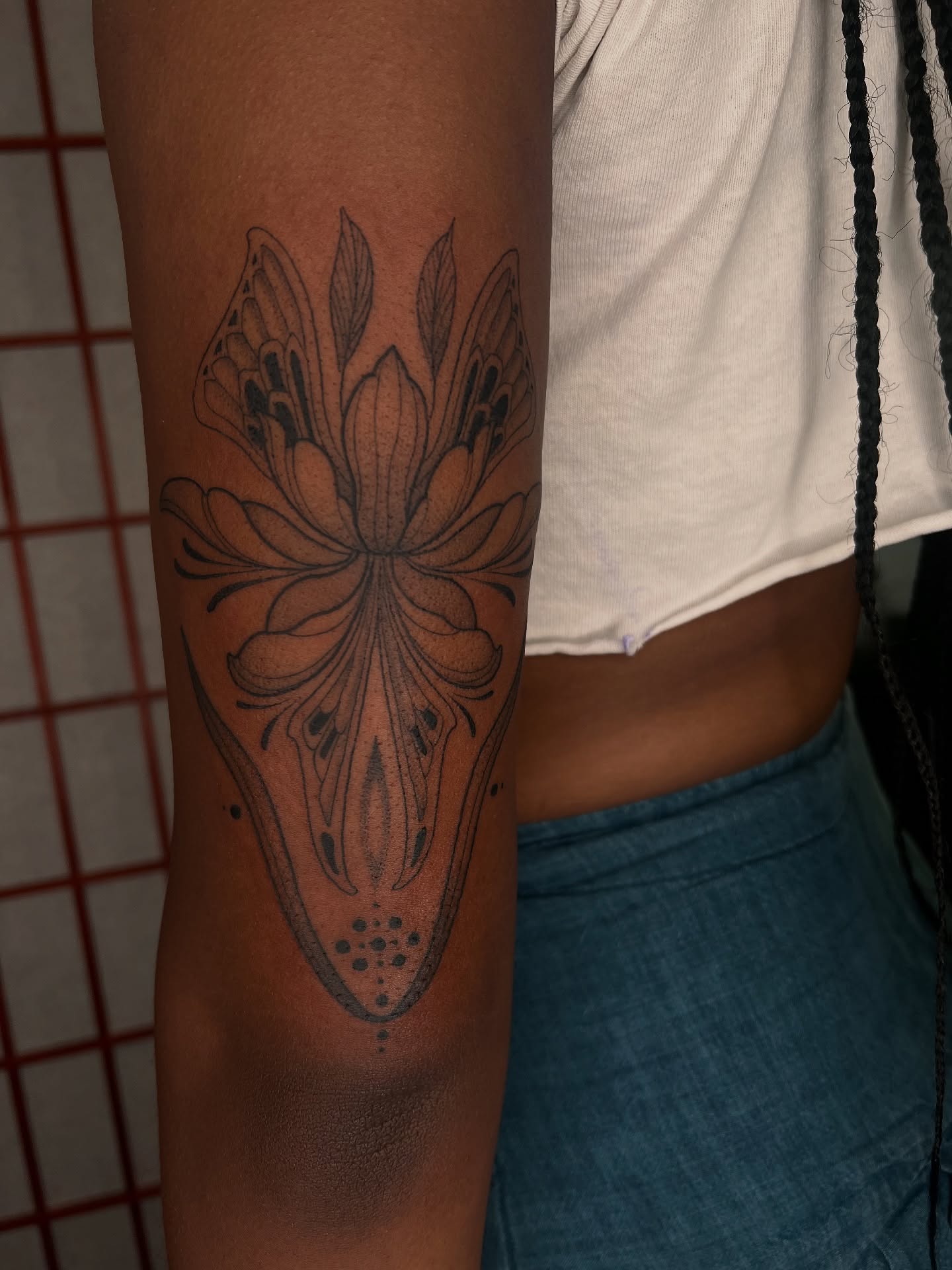 Lotus flower dotwork tattoo on the forearm by Avrey Simone