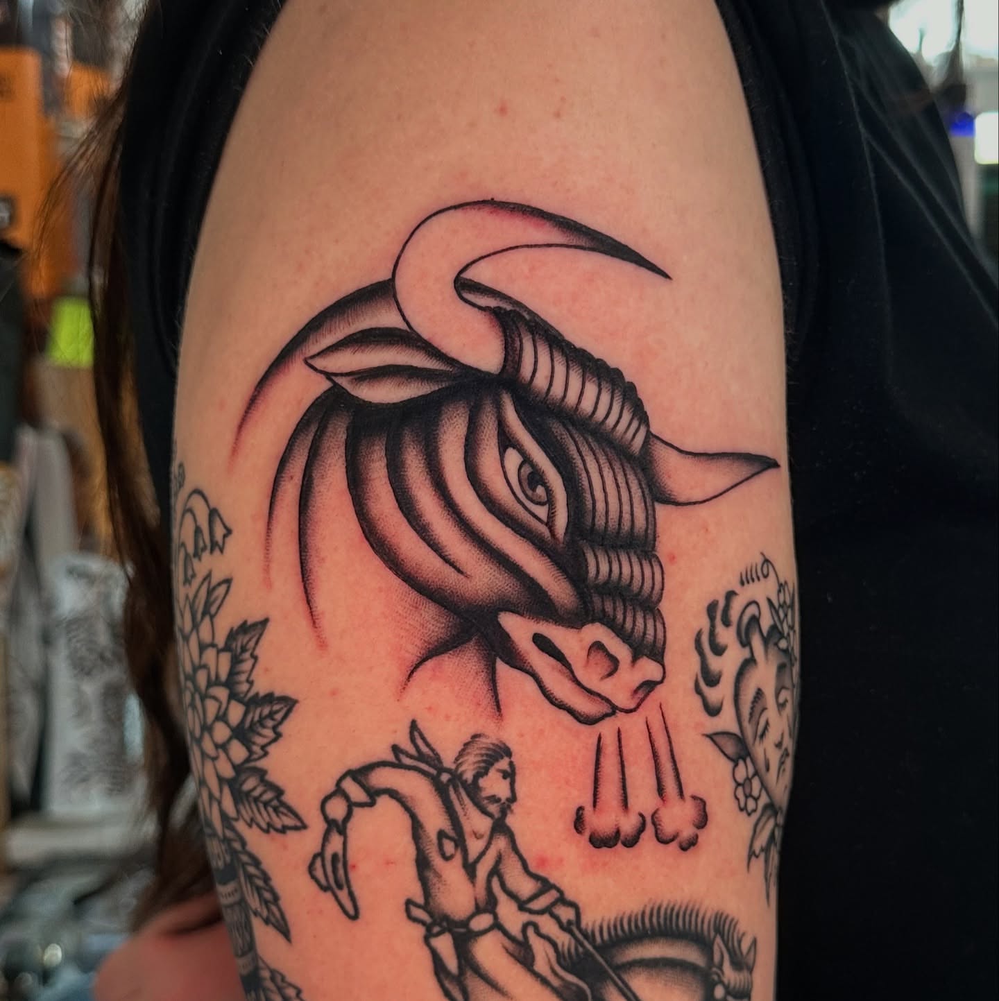 Bull head black and grey tattoo on the upper arm by Max Peterson