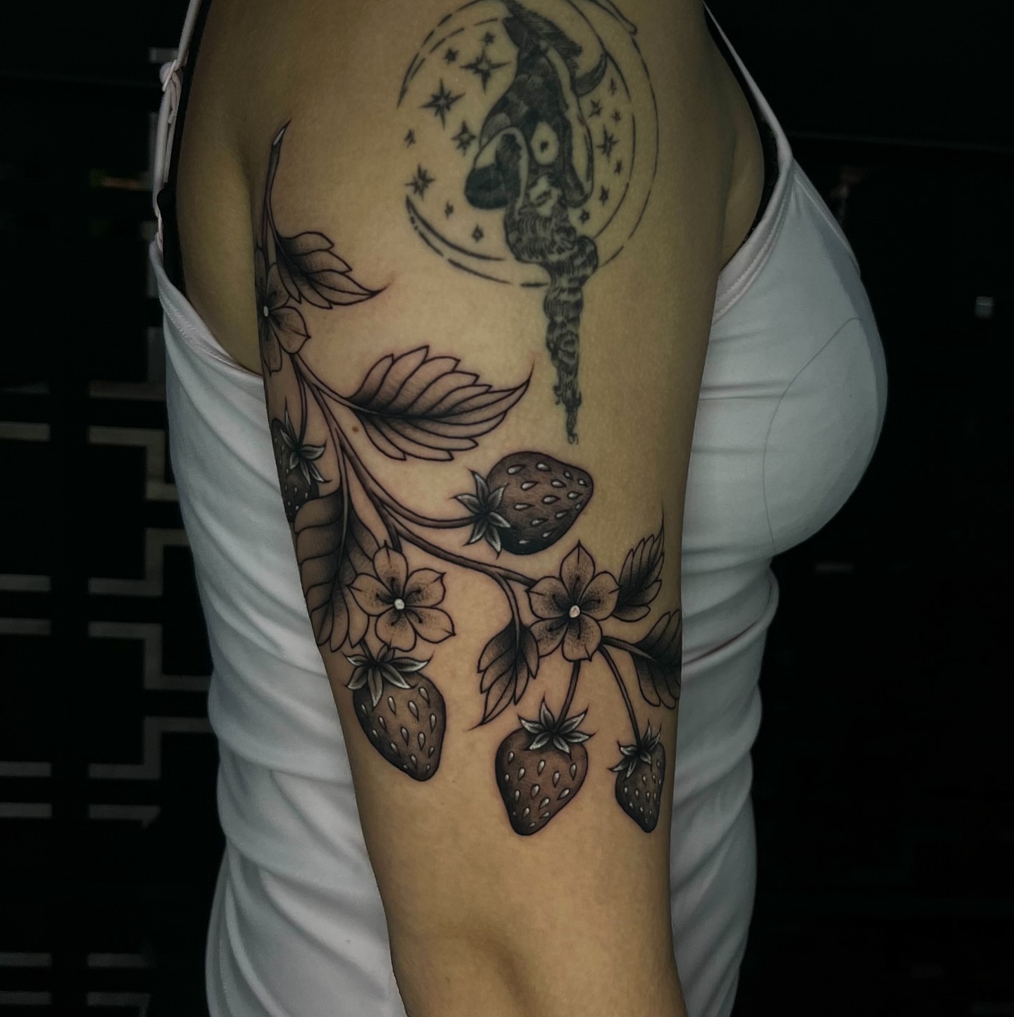 Strawberries and flowers black and grey tattoo on the forearm by Connor Arvay