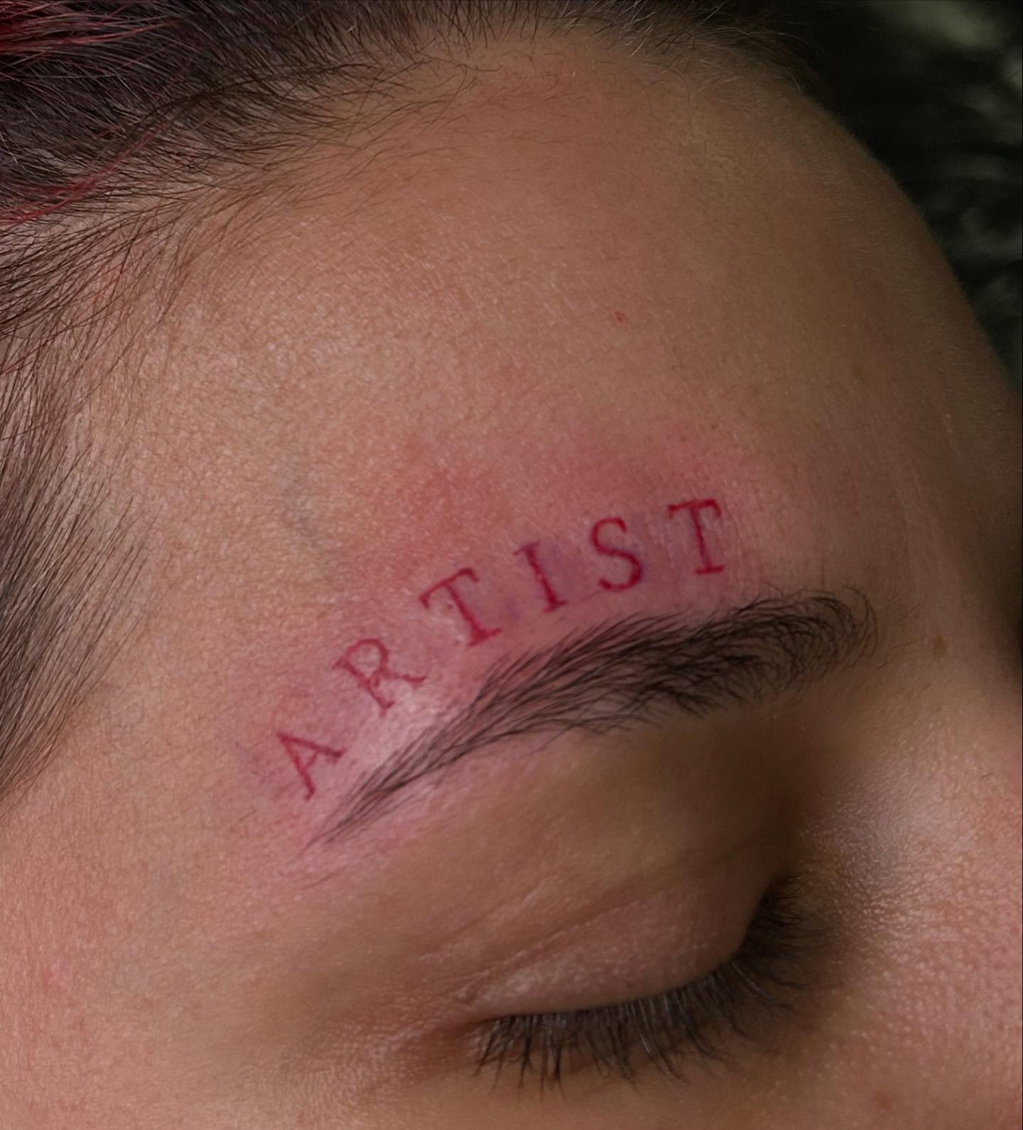 Artist lettering script tattoo on the head by Victoria Mendez
