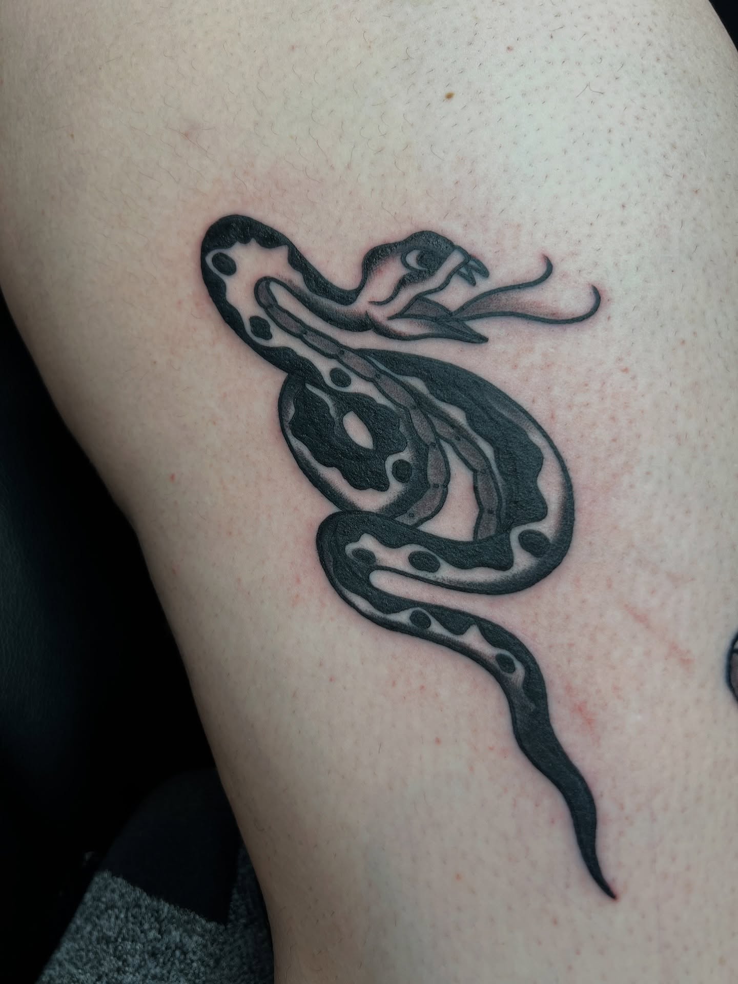 Snake black and grey tattoo on the thigh by Cory Miller