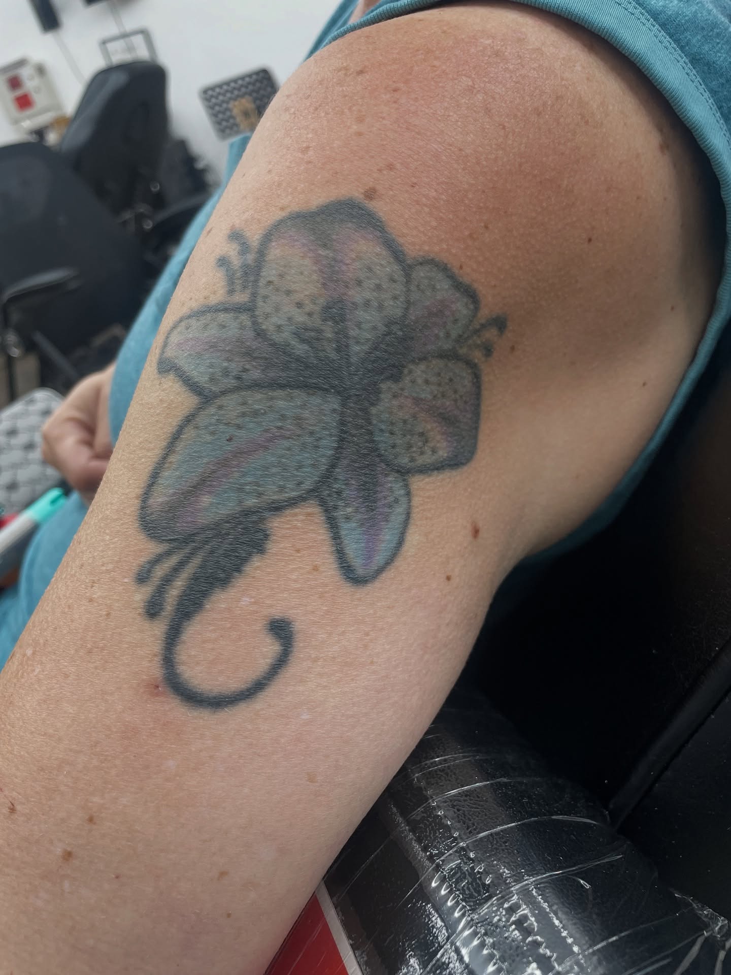 Flower black and grey tattoo on the upper arm by Cultura