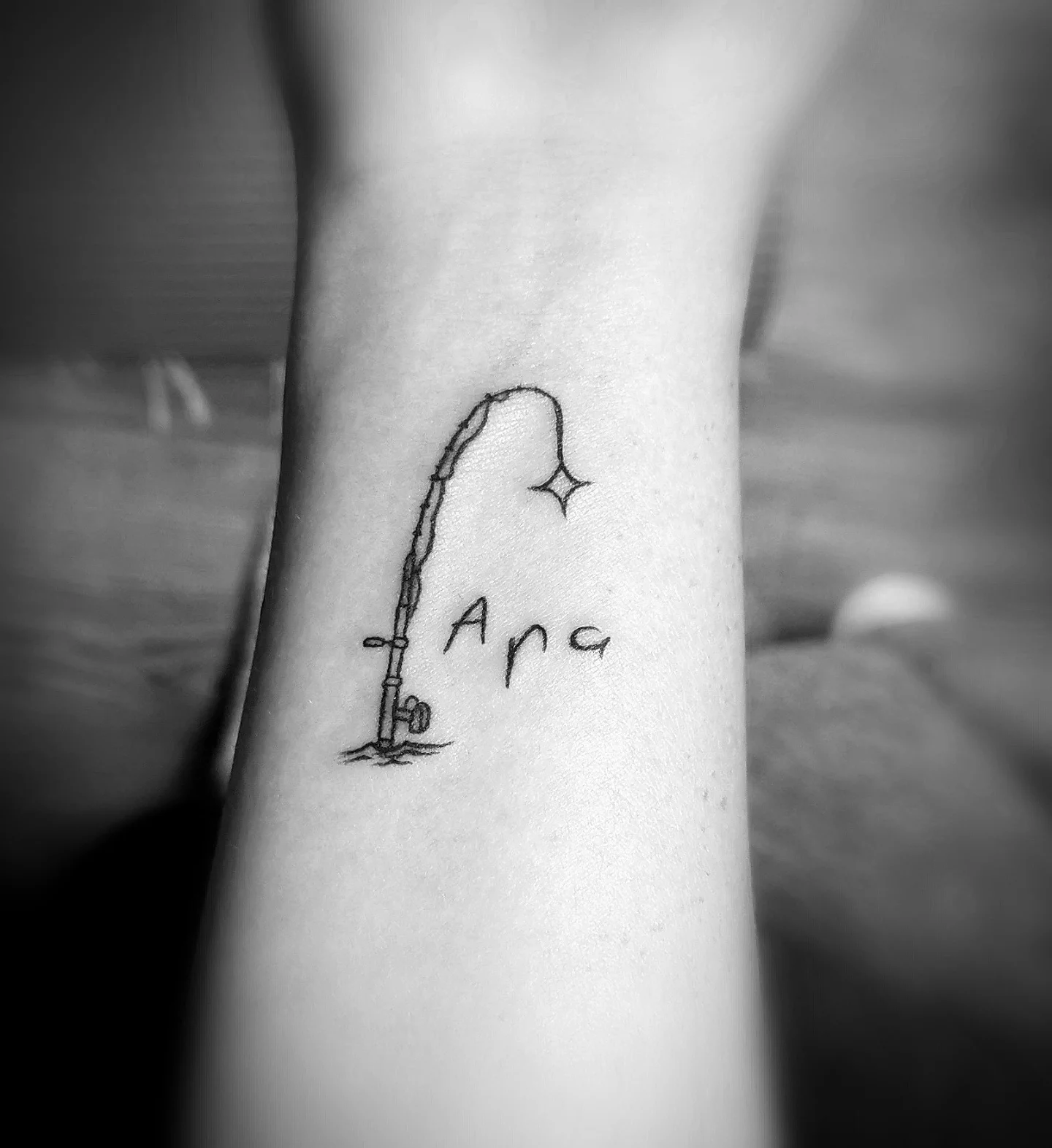Fishing rod and star fine line tattoo on the forearm by Ink of Winchester