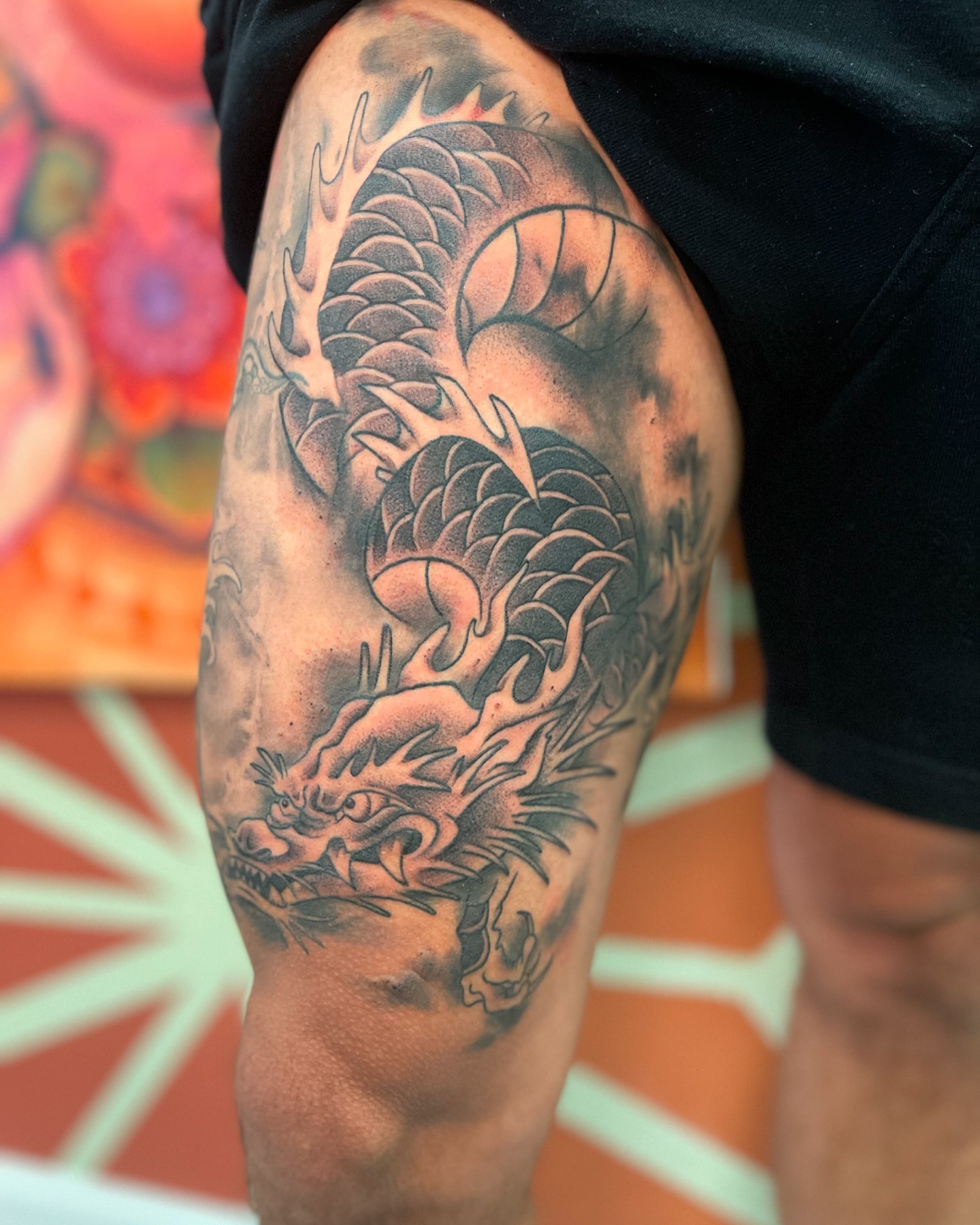 Dragon black and grey tattoo on the thigh by Alex