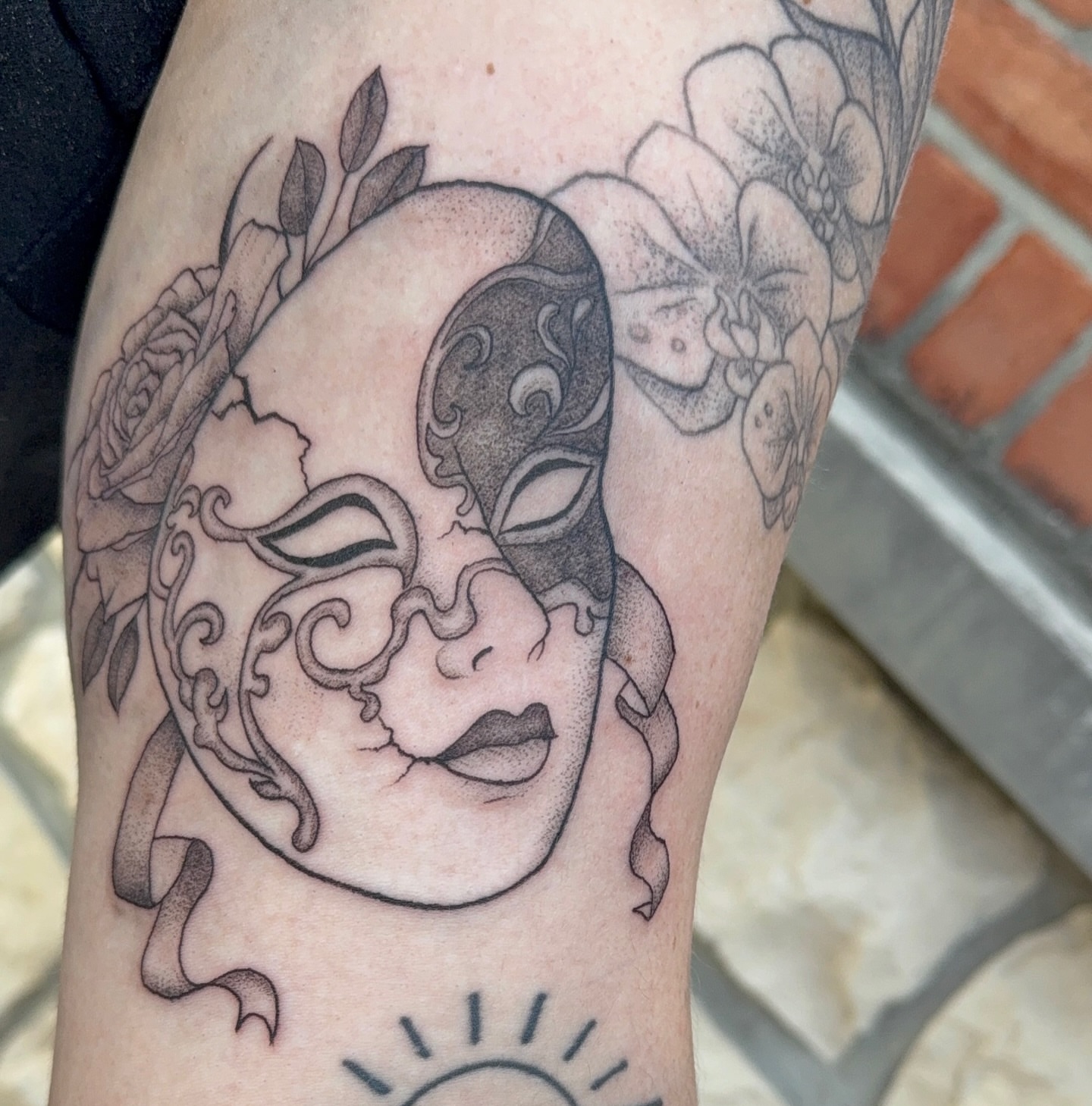 Mask and floral dotwork tattoo on the forearm by Tina Petrullo, West Chester Township, Butler County, Ohio