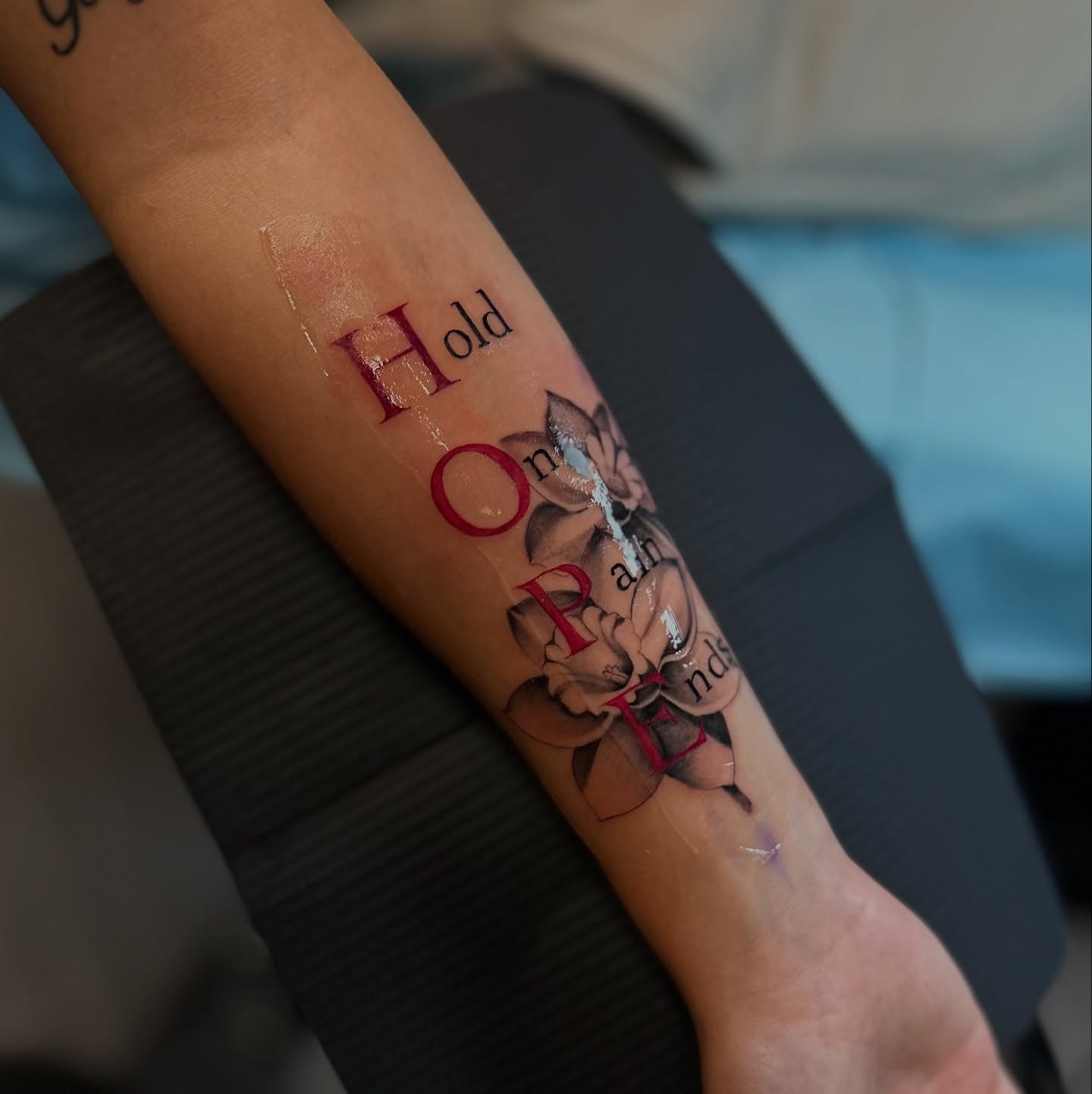 Hope and flowers lettering script tattoo on the forearm by mssinderella