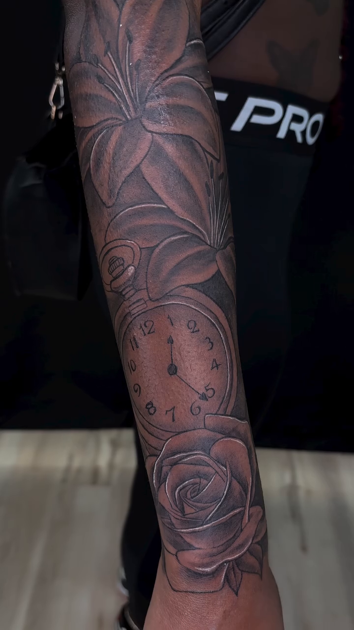 Rose, clock, and leaves realism tattoo by Dinero Inks
