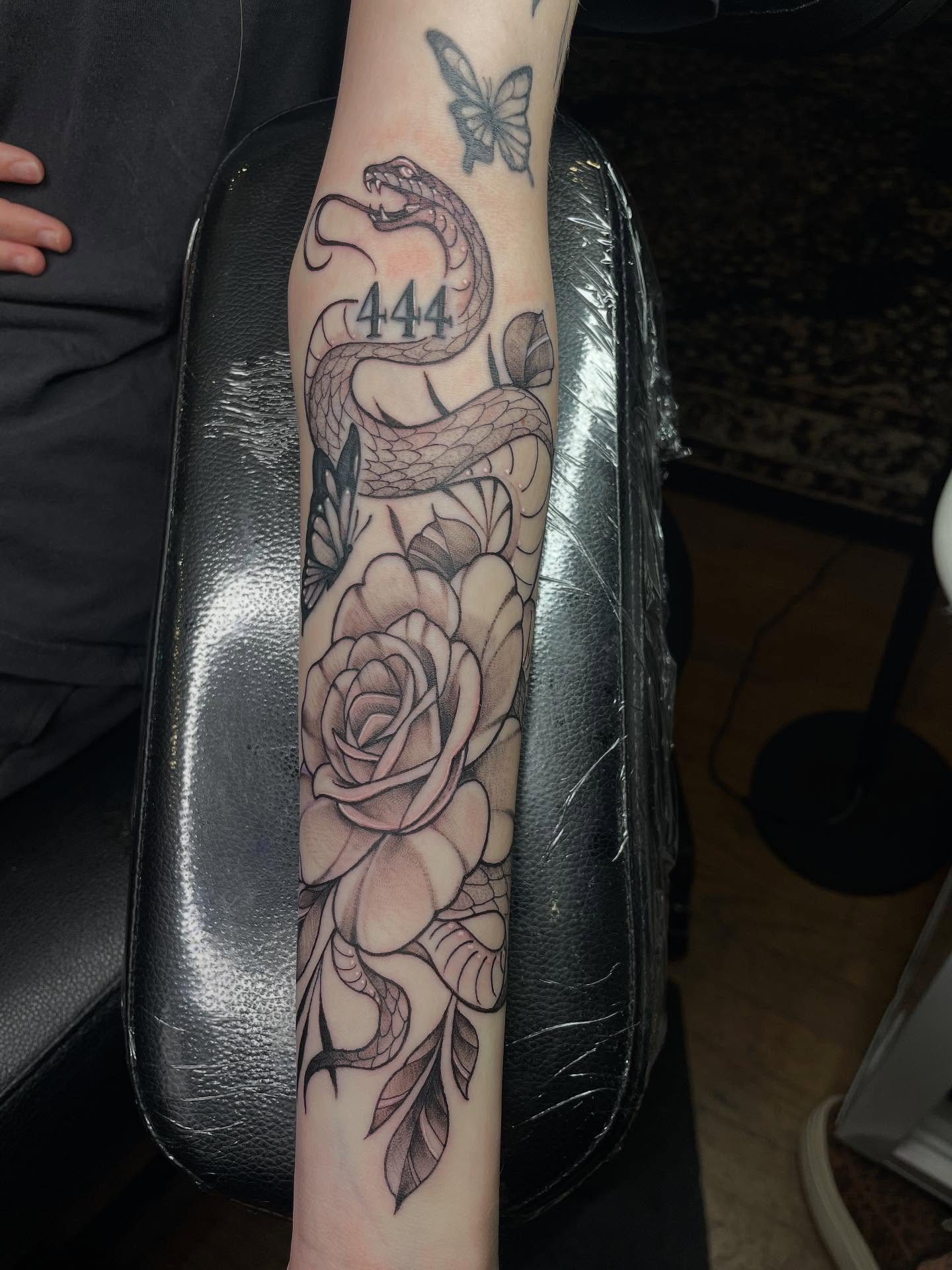 Snake and roses black and grey tattoo on the forearm by Lauren Sisouphanh, Canton, Ohio