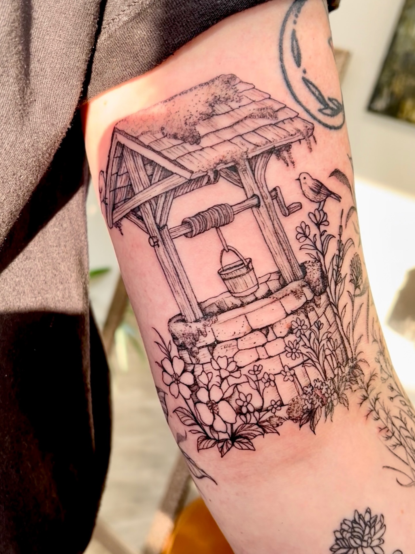 Wishing well black and grey tattoo on the forearm by Amanda Morris