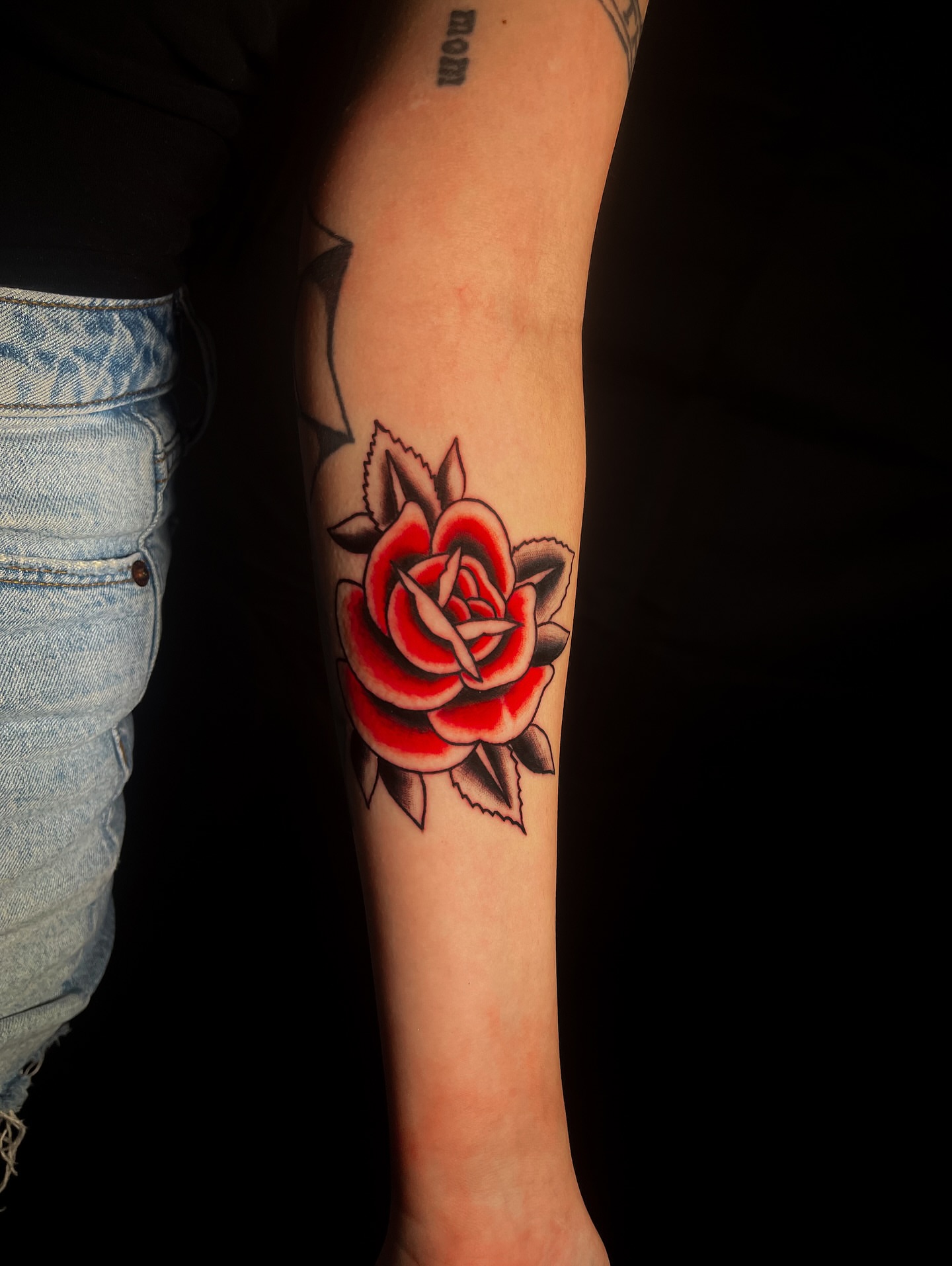 Red rose American traditional tattoo on the forearm by Miguel Henrik