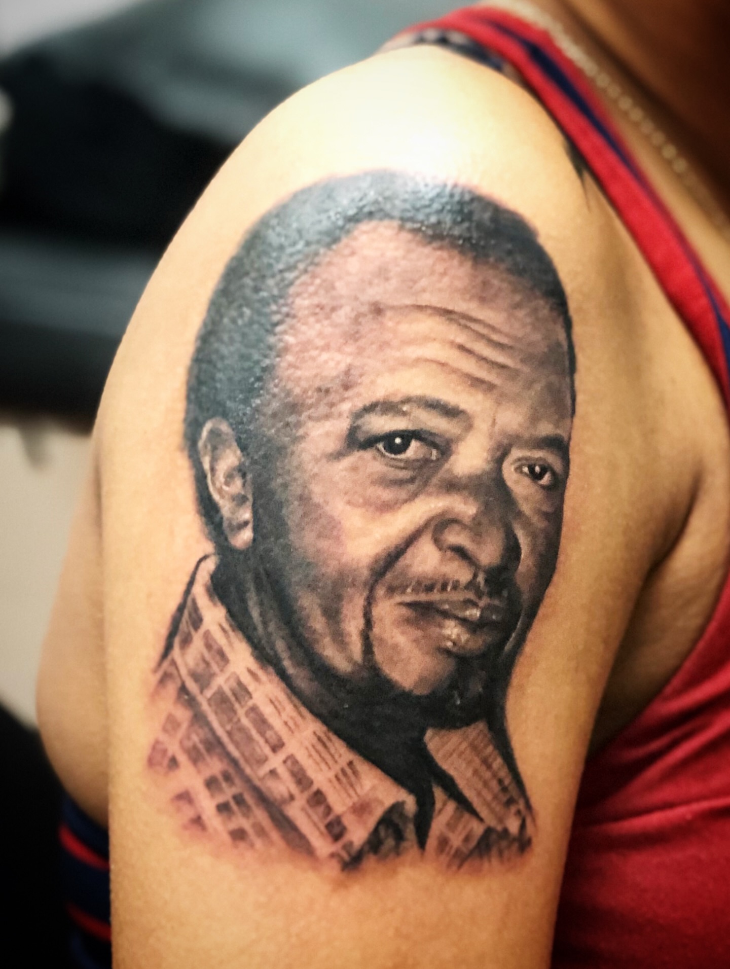 Portrait realism tattoo on the shoulder by Ray Wiggins