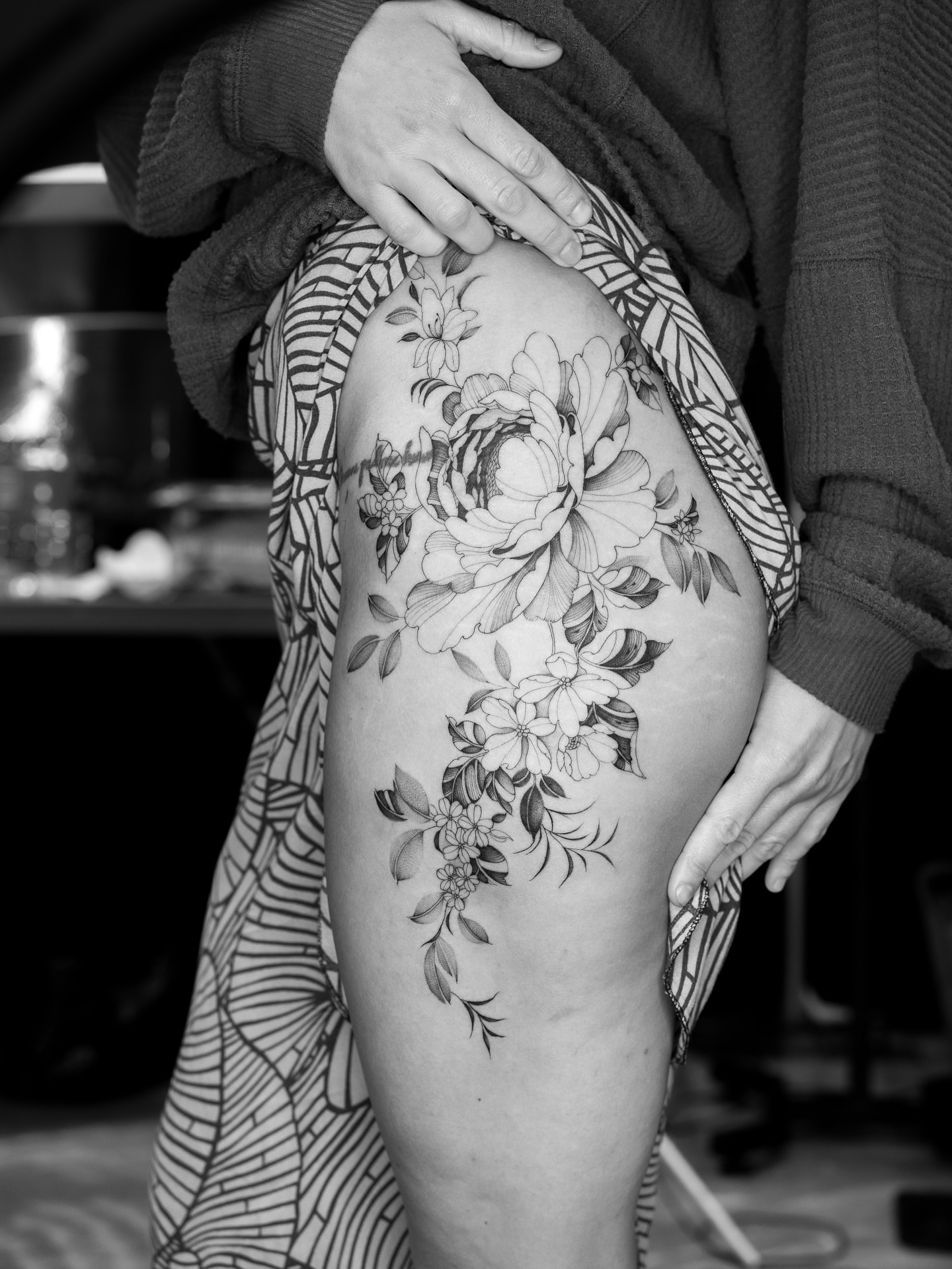 Floral arrangement black and grey tattoo on the thigh by Leo Gao