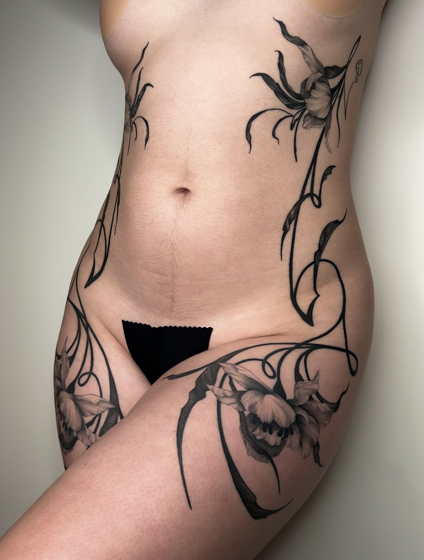 Floral vine realism tattoo on the thigh by Crystal Thorns