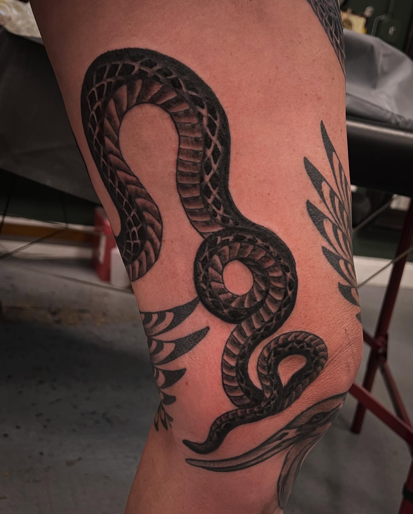 Snake black and grey tattoo on the thigh by Matt E.