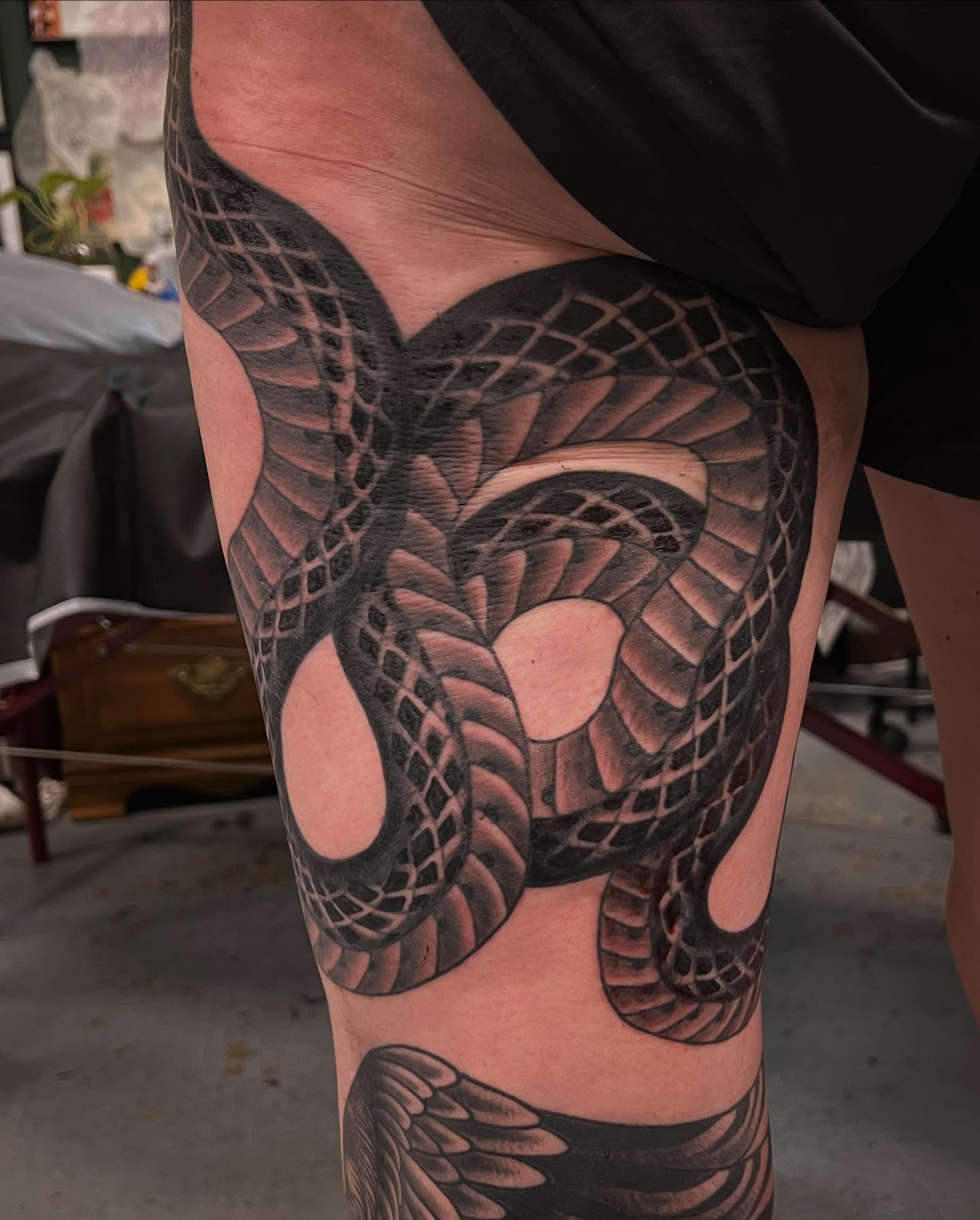 Snake black and grey tattoo on the thigh by Matt E.