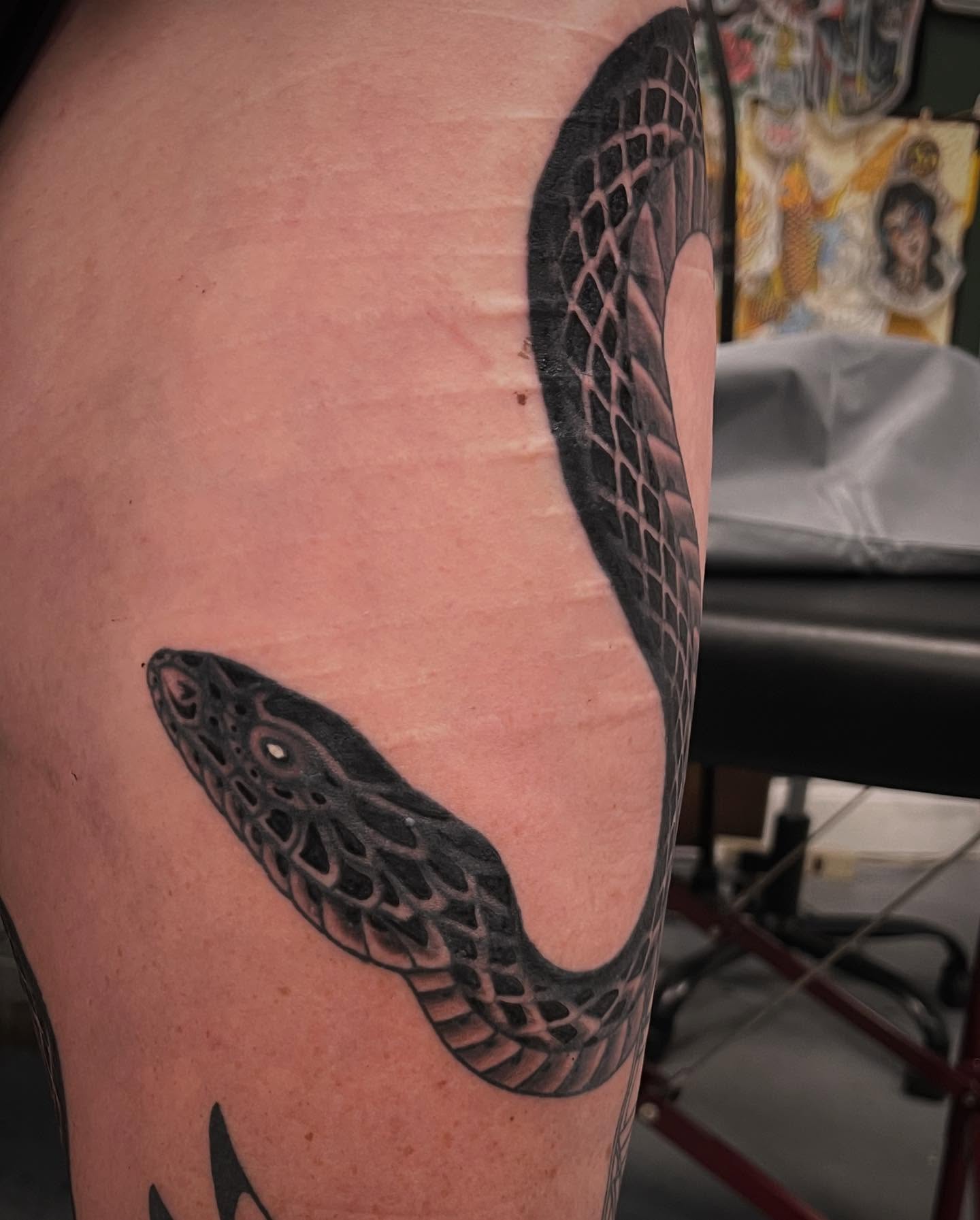 Snake black and grey tattoo on the thigh by Matt E.